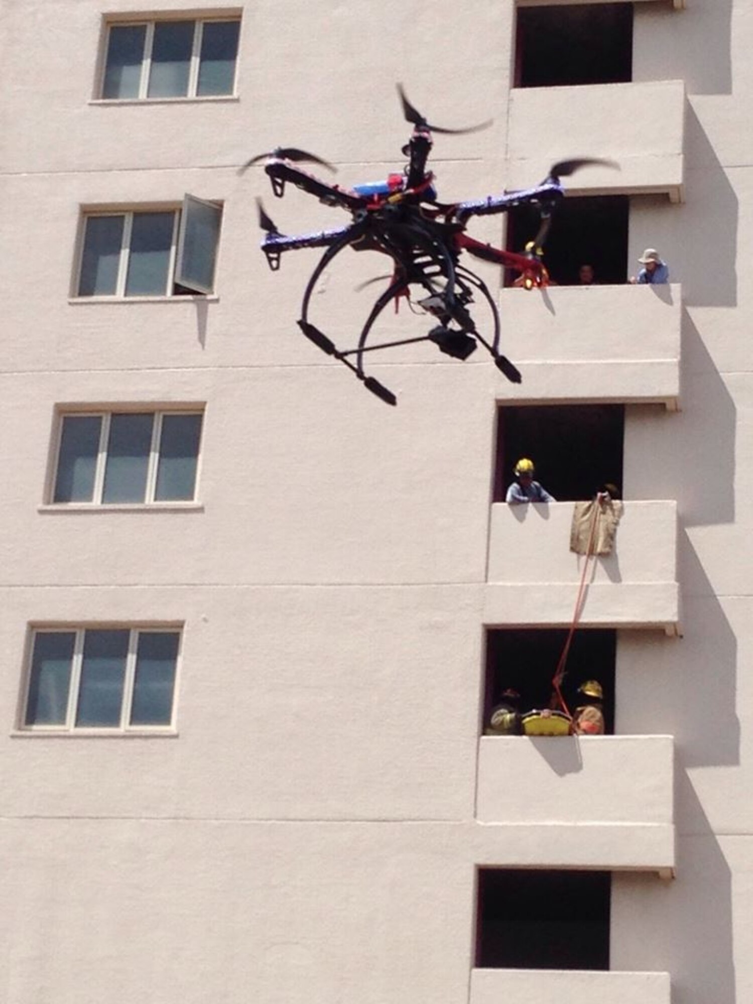 A drone hovers outside the Onward Beach Resort, Tamuning, Guam, as the Guam Fire Department simulates a fifth floor structure fire with a trapped victim in a fire exit drill and rescue as part of Fire Prevention Week, Oct. 9, 2014. Guam hasn't had any major high-rise emergencies because of strict international fire codes that enforce fire protection systems. Many Air Force Reserve members, such as Chief Master Sgt. Joey Manibusan, serve fulltime with the Guam Fire Department, in addition to drilling one weekend a month and two weeks per year with the 44th Aerial Port Squadron or 624th Aerospace Medicine Squadron, located at Andersen Air Force Base, Guam. (Courtesy photo/Guam Fire Department)