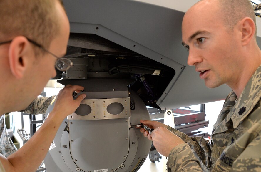 Lt. Col. Scott, 11th Reconnaissance Squadron director of operations, right, asks a question to Senior Airman William Little, 727th Special Operations Aircraft Maintenance Squadron avionics specialist from Cannon Air Force Base, New Mexico, during an MQ-9 Reaper build Oct. 22, 2014, at Creech Air Force Base, Nevada. The build was part of an integration training program to help build relationships between the operations and maintenance units on base. (U.S. Air Force photo by Staff Sgt. Adawn Kelsey/released some names have been withheld for security purposes)