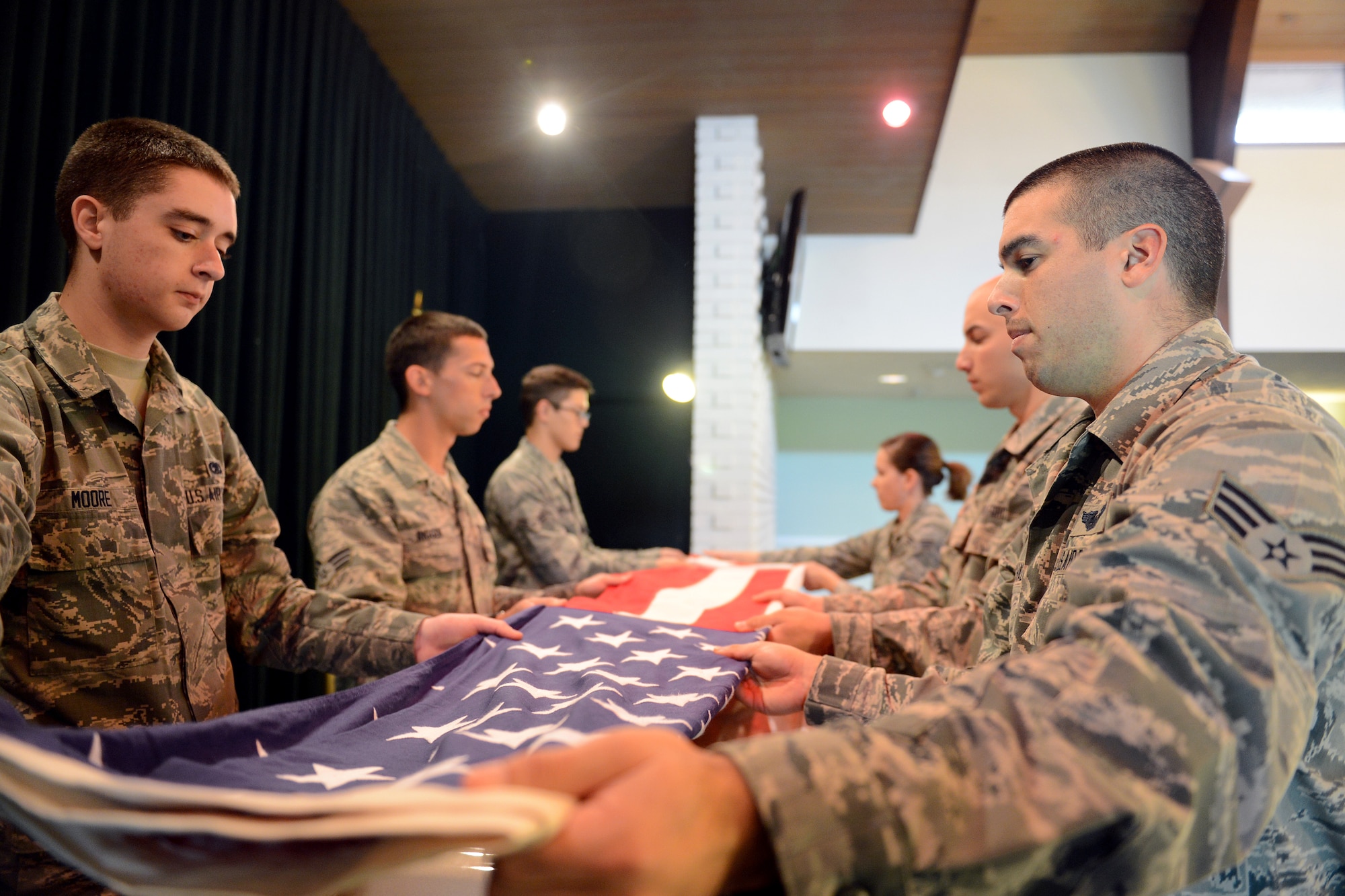 Six members of McChord Field’s Honor Guard hold a flag to prepare it to be folded Oct. 29, 2014, during a practice funeral in Tacoma, Wash. During their two week training upon joining the honor guard, the trainees learn everything they will need to know to complete a detail. (U.S. Air Force photo/Airman 1st Class Keoni Chavarria)