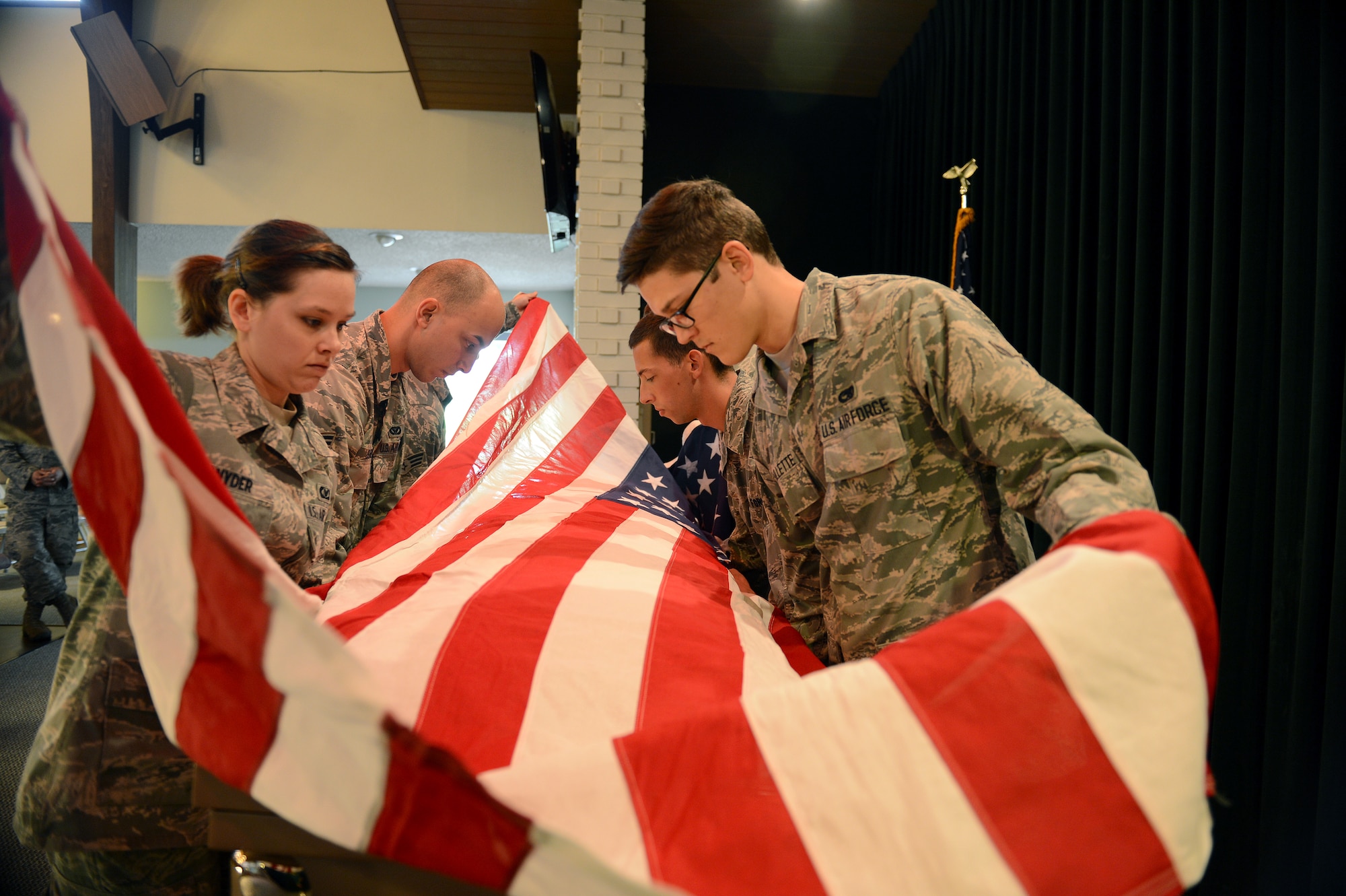 Six members of McChord Field’s Honor Guard practice folding a flag Oct. 29, 2014, during a practice funeral in Tacoma, Wash. During the funeral detail, the honor guard members must work to complete the detail while keeping their military bearing through obstacles such as disrupting members of the audience. (U.S. Air Force photo/Airman 1st Class Keoni Chavarria)