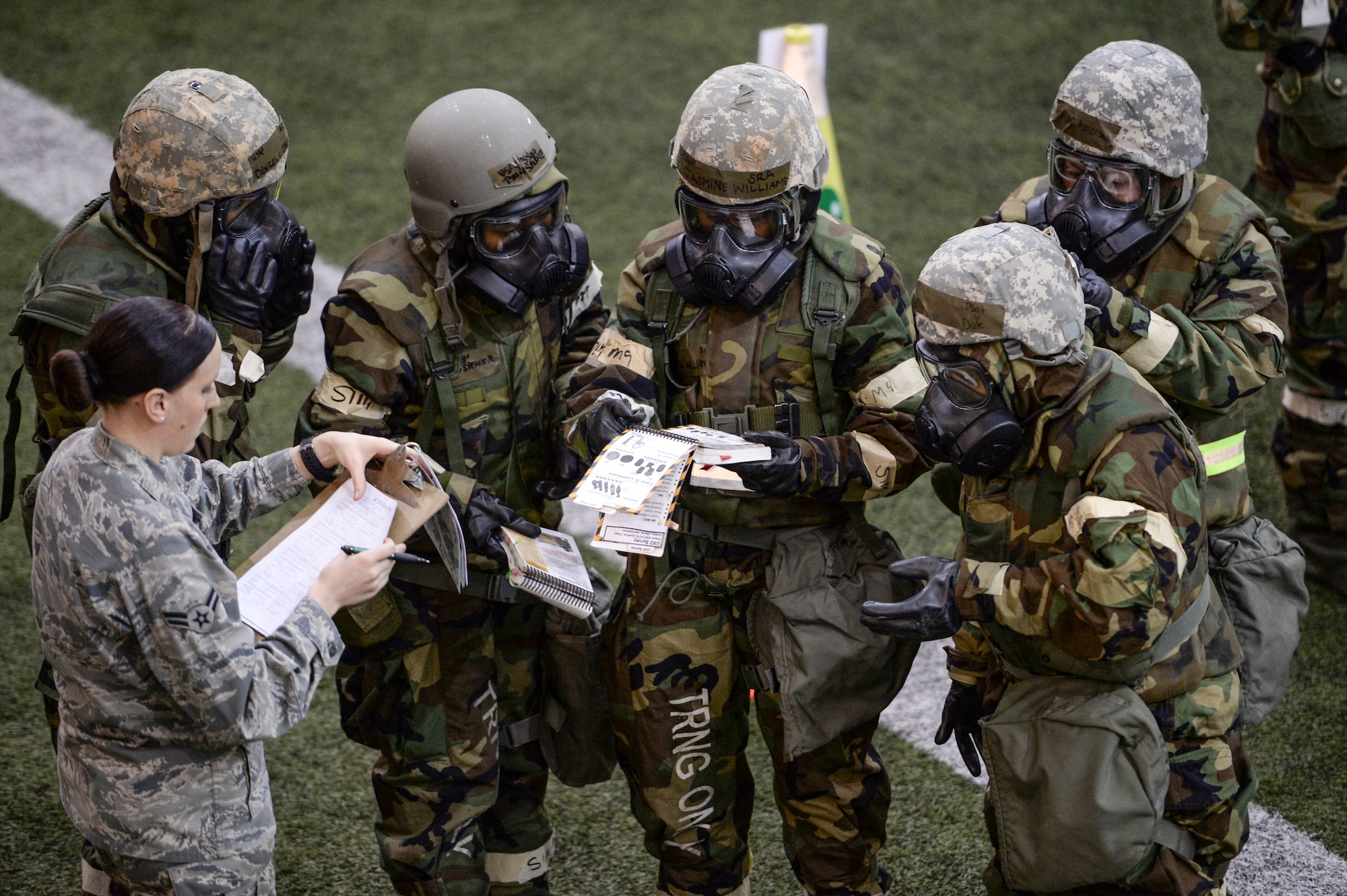 U.S. Airmen review unexploded ordnance guidance in Airmen's Manuals Oct. 28, 2014, during ability to survive and operate (ATSO) training at Eielson Air Force Base, Alaska. The ATSO training tested Eielson Icemen with various emergency situations including chemical attack, unexploded ordnance and self-aid and buddy care. (U.S. Air Force photo by Senior Airman Peter Reft/Released)