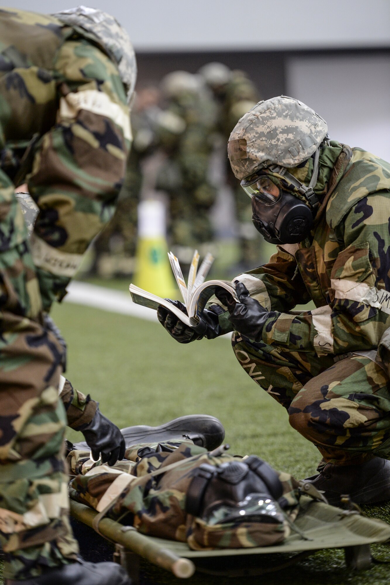 U.S. Airmen check self-aid and buddy care (SABC) guidelines in an Airman's Manual Oct. 28, 2014, during ability to survive and operate (ATSO) training at Eielson Air Force Base, Alaska. The ATSO training tested Airmen with various emergency situations including chemical attack, unexploded ordnance and SABC. (U.S. Air Force photo by Senior Airman Peter Reft/Released)