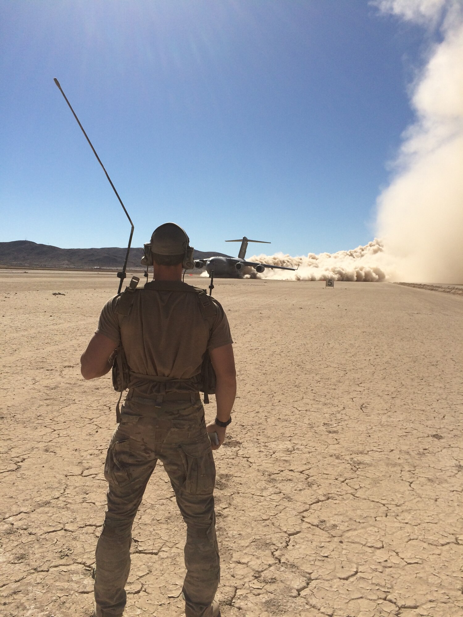 A member of the 22nd Special Tactics Squadron out of McChord AFB, Wash., look on following the landing of a C-17 in a dry lake bed. The Airman was at Kirtland in support of the  57th Weapons Squadron's four-week Composite Mission Application phase training, part of the U.S. Air Force Weapons School curriculum. Six students tackled eight flying missions, including landing the aircraft in austere conditions. (Courtesy photo)