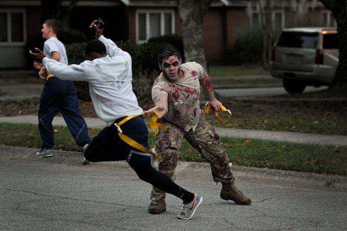 A zombie tries to grab a runner’s flag during the Joint Base Charleston Combined Federal Campaign Zombie Run Oct. 31, 2014, at JB Charleston, S.C. The 1.7 mile run forced runners to dodge zombies in three "contaminated" areas in order to "survive." (U.S. Air Force photo/Staff Sgt. Renae Pittman)