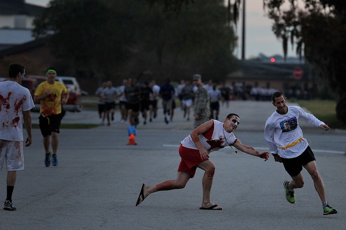 A runner tries to escape the clutches of a zombie during the Joint Base Charleston Combined Federal Campaign Zombie Run Oct. 31, 2014 at JB Charleston, S.C. The 1.7 mile run forced runners to dodge zombies in three "contaminated" areas in order to "survive." (U.S. Air Force photo/Staff Sgt. Renae Pittman)
