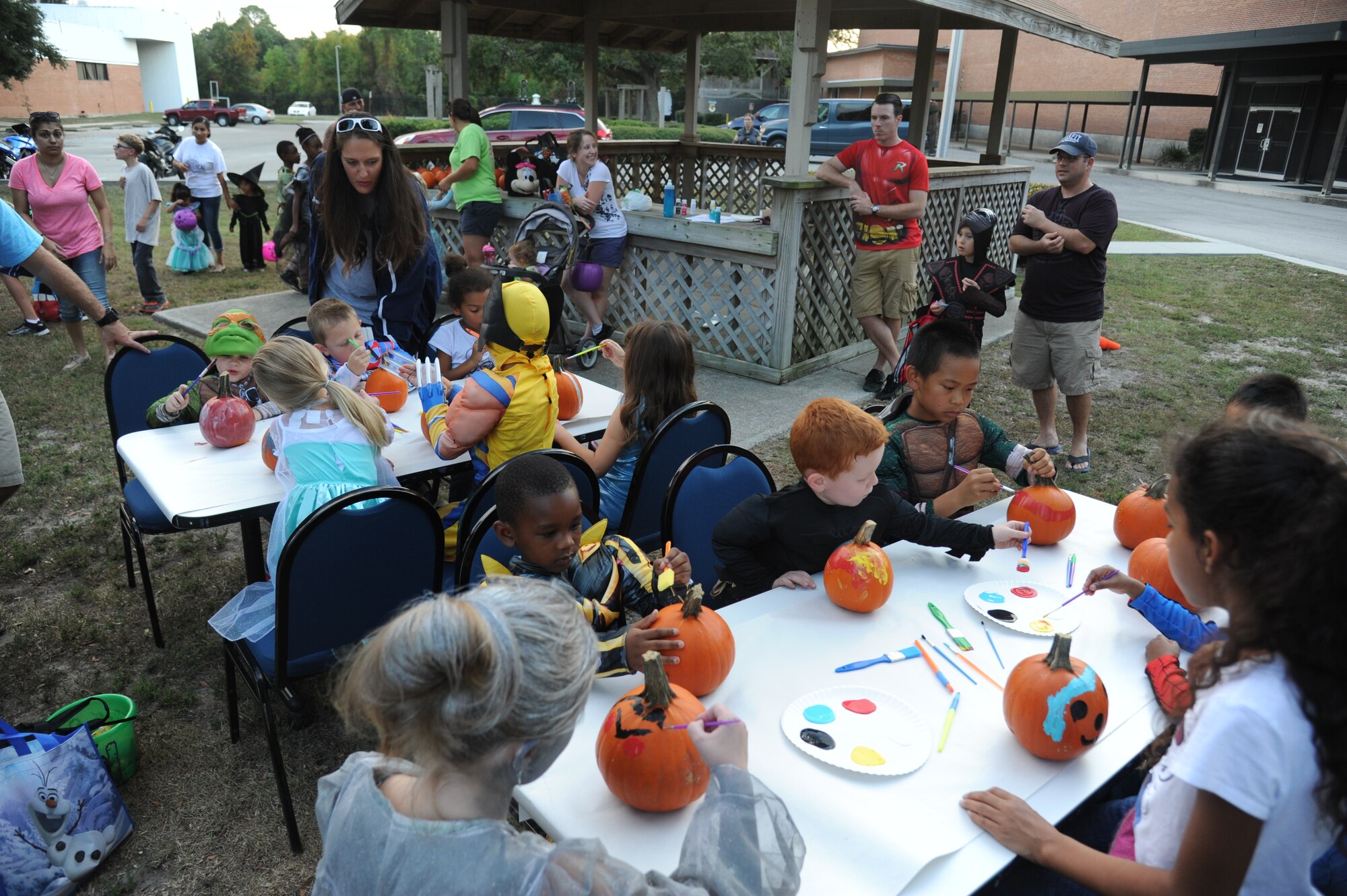 Members of the 85th Engineering Installation Squadron watch their children paint pumpkins during the 2nd Annual 85th EIS Trunk-Or-Treat Oct. 29, 2014, at Maltby Hall, Keesler Air Force Base, Miss.  The event also included a costume contest and trunk-or-treating.  (U.S. Air Force photo by Kemberly Groue)