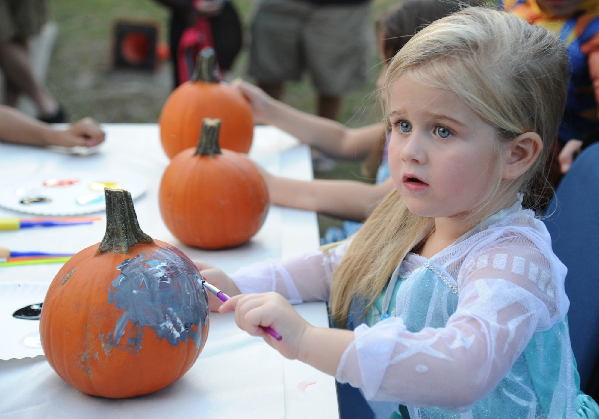 The daughter of Staff Sgt. Simon Martin, 85th Engineering Installation Squadron, paints a pumpkin during the 2nd Annual 85th EIS Trunk-Or-Treat Oct. 29, 2014, at Maltby Hall, Keesler Air Force Base, Miss.  The event also included a costume contest and trunk-or-treating. (U.S. Air Force photo by Kemberly Groue)