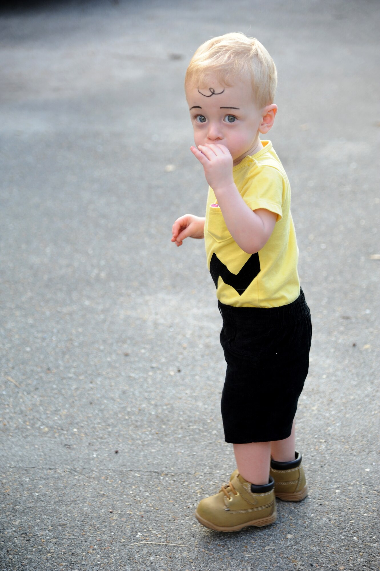 The son of Senior Airmen Brenden and Jessica Wright, 85th Engineering Installation Squadron, eats a piece of candy as he is dressed up as the cartoon character, Charlie Brown, during the 2nd Annual 85th EIS Trunk-Or-Treat Oct. 29, 2014, at Maltby Hall, Keesler Air Force Base, Miss.  The event included a costume contest, trunk-or-treating and pumpkin painting.  (U.S. Air Force photo by Kemberly Groue)