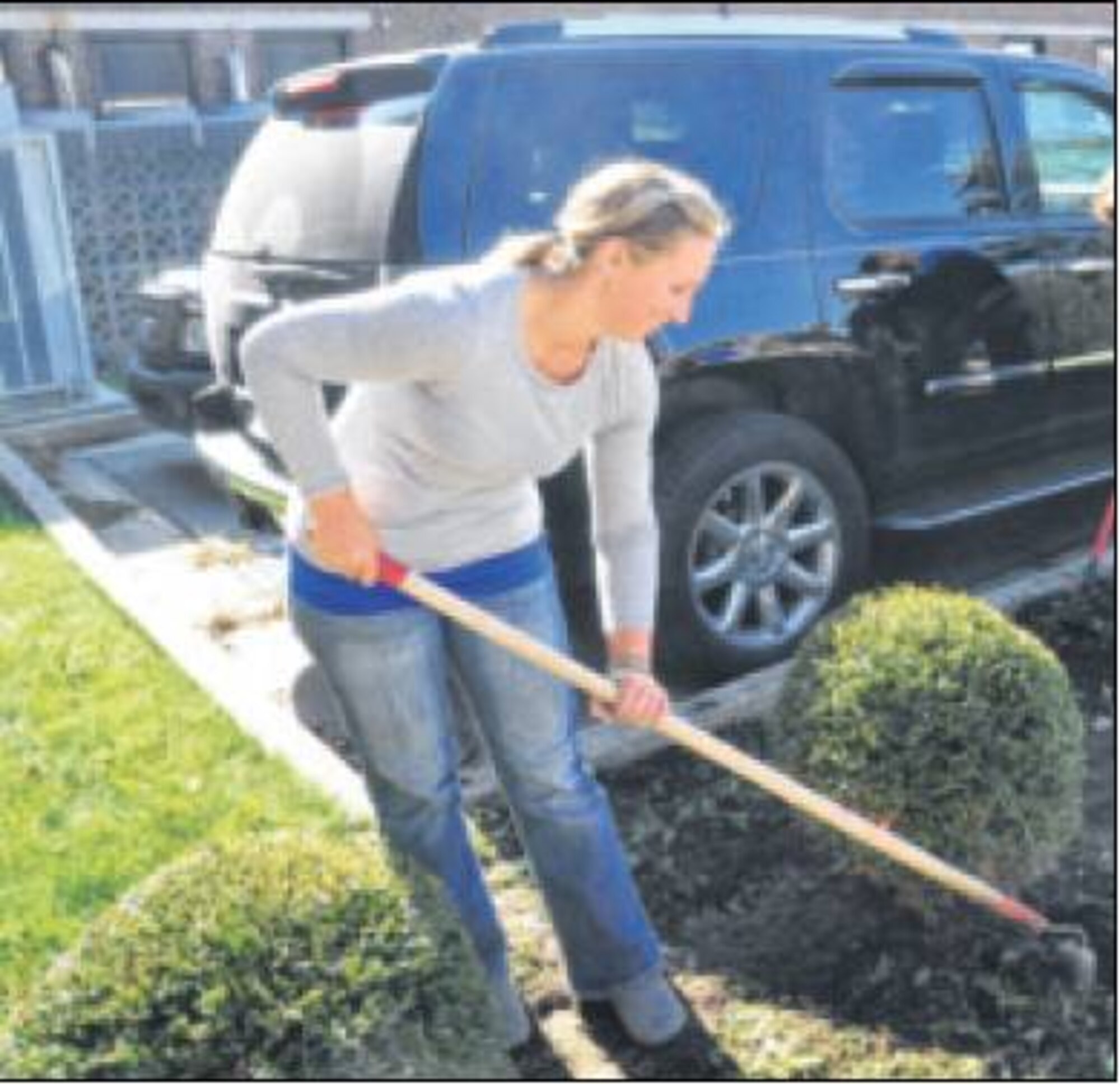 Molly Holtzapple, management analyst, assists in a cleanup of the landscape outside of building 10. (Air Force photos by Diane Kofoed) 


