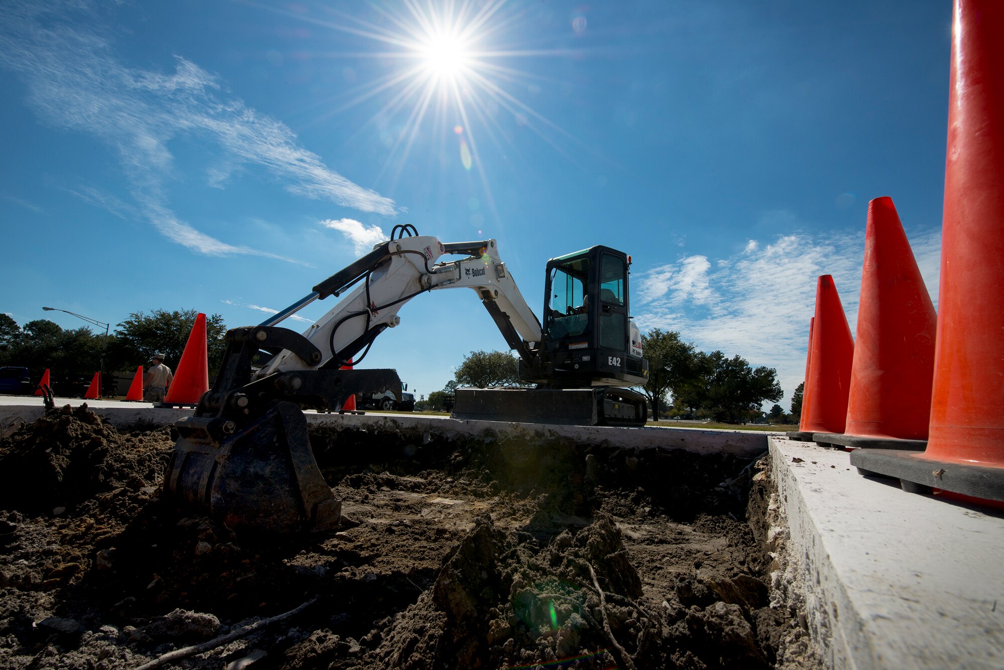 Airmen from the 23d Civil Engineer Squadron use an excavator to flatten the bottom of a hole Oct. 29, 2014, at Moody Air Force Base, Ga. The Airmen were preparing the President George W. Bush Air Park to display an HC-130P Combat King. (U.S. Air Force photo by Airman 1st Class Ryan Callaghan/Released)