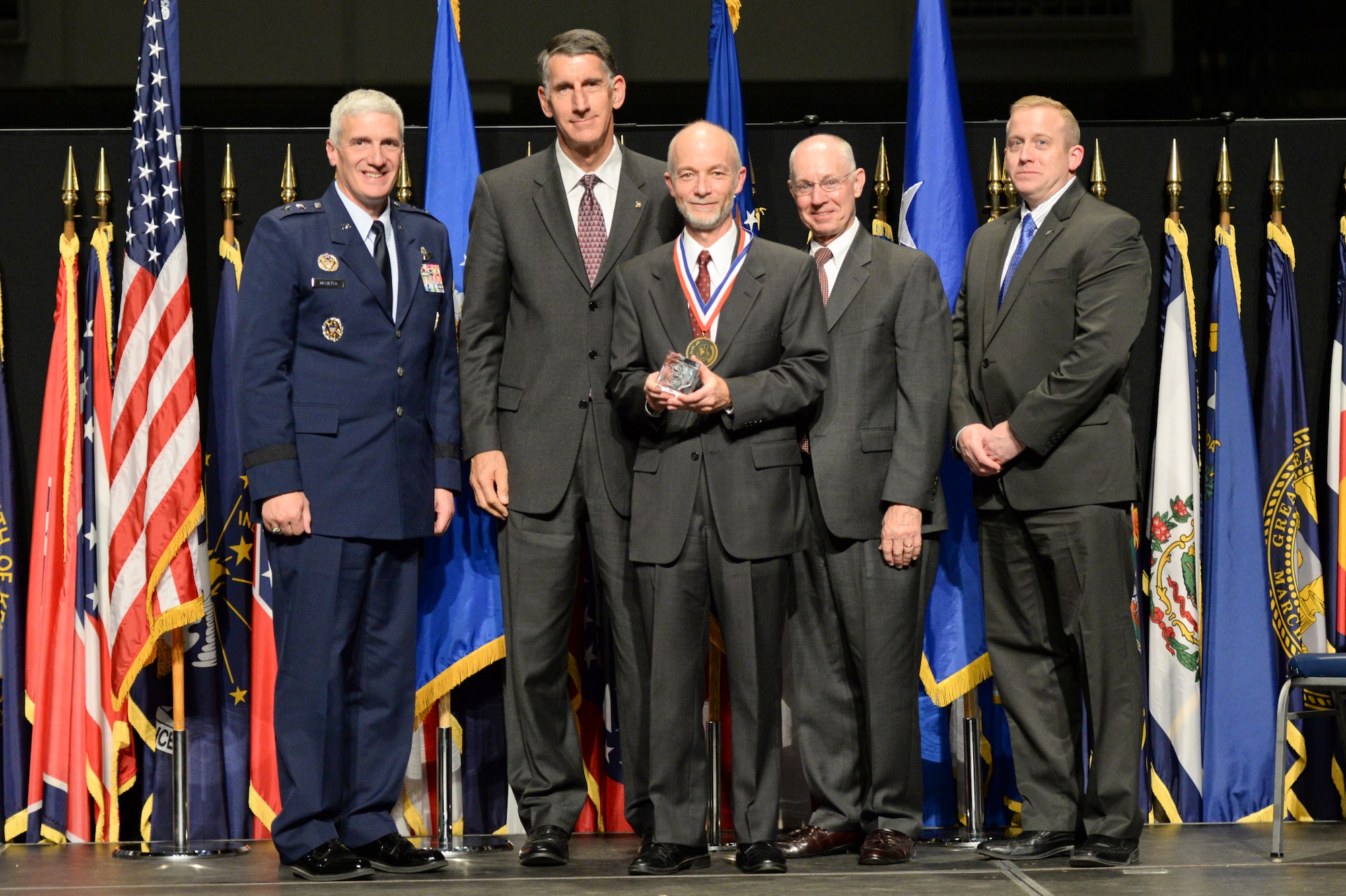 Dr. Gregory Vansuch, technical advisor, Systems Technology Office, Air Force Research Laboratory Sensors Directorate, is honored during the 2014 AFRL Fellows and Early Career Awards Banquet Oct. 30 at the National Museum of the U.S. Air Force,  Joining him are Maj. Gen. Tom Masiello, AFRL commander, Dr. Vansuch's mentor, Dr. Gregory Schneider, retired AFRL commander, Maj. Gen. Dick Paul, and Dr. Morley Stone, AFRL chief technology officer. (U.S. Air Force photo/Wesley Farnsworth) 