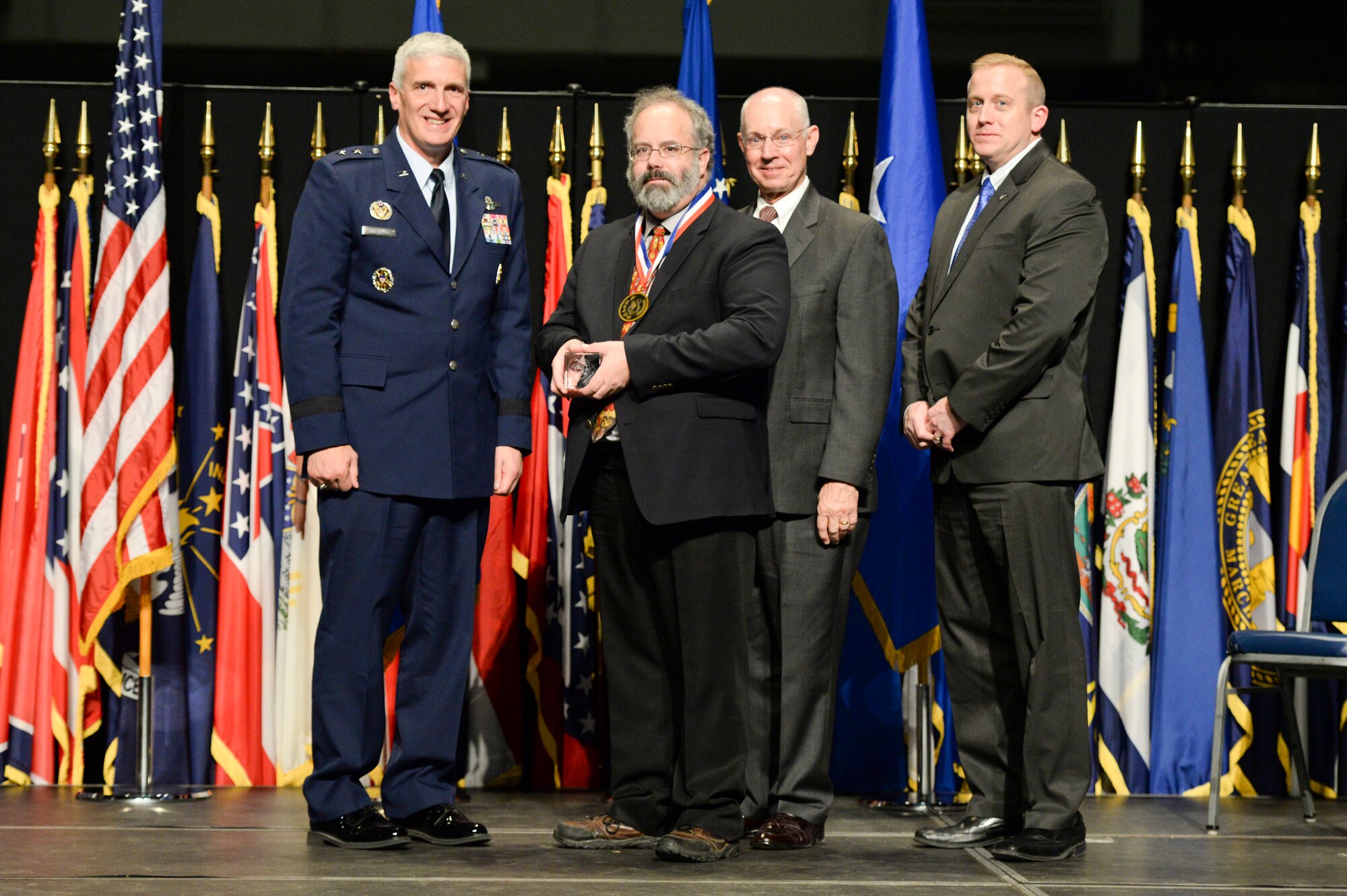 Mr. Ralph Kohler, principal engineer, Air Force Research Laboratory Information Directorate, is honored during the 2014 AFRL Fellows and Early Career Awards Banquet, Oct. 30 at the National Museum of the U.S. Air Force. Joining him are Maj. Gen. Tom Masiello, AFRL commander, retired Maj. Gen. Dick Paul, AFRL's first commander, and Dr. Morley Stone, AFRL chief technology officer.  (U.S. Air Force photo/Wesley Farnsworth)