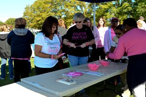 Fort Eustis community members look at pamphlets, bracelets and other items before the Breast Cancer Awareness Month walk at Fort Eustis, Va., Oct. 30, 2014. National Breast Cancer Awareness Month began in 1985 to provide awareness, education and empowerment. (U.S. Air Force photo by Airman 1st Class Kimberly Nagle/Released) 