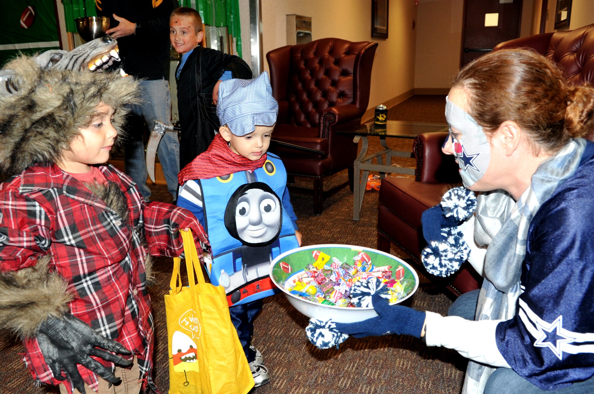 Senior Master Sgt. Shae Alamo, 319th Medical Group superintendent, offers candy to children at the 319th Medical Group Oct. 30, 2014, for the clinic’s annual trick-or-treat event. Each office in the clinic created its own theme where children could collect candy, dance to music, and even watch scenes from popular movies. (U.S. Air Force photo/Staff Sgt. Susan L. Davis) 