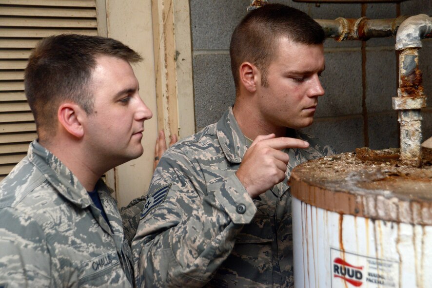 Staff Sgt. Steven Stein, 56th Civil Engineer Squadron electrical subject matter expert, points out a damaged water heater Oct. 24 to Senior Airman Sandham Challis, 56th CES structural subject matter expert, in Bldg. 700 during a building inspection at Luke Air Force Base. The heater is more than 20 years old and was scheduled for replacement during the inspection. (U.S. Air Force photo/Staff Sgt. Timothy Boyer)