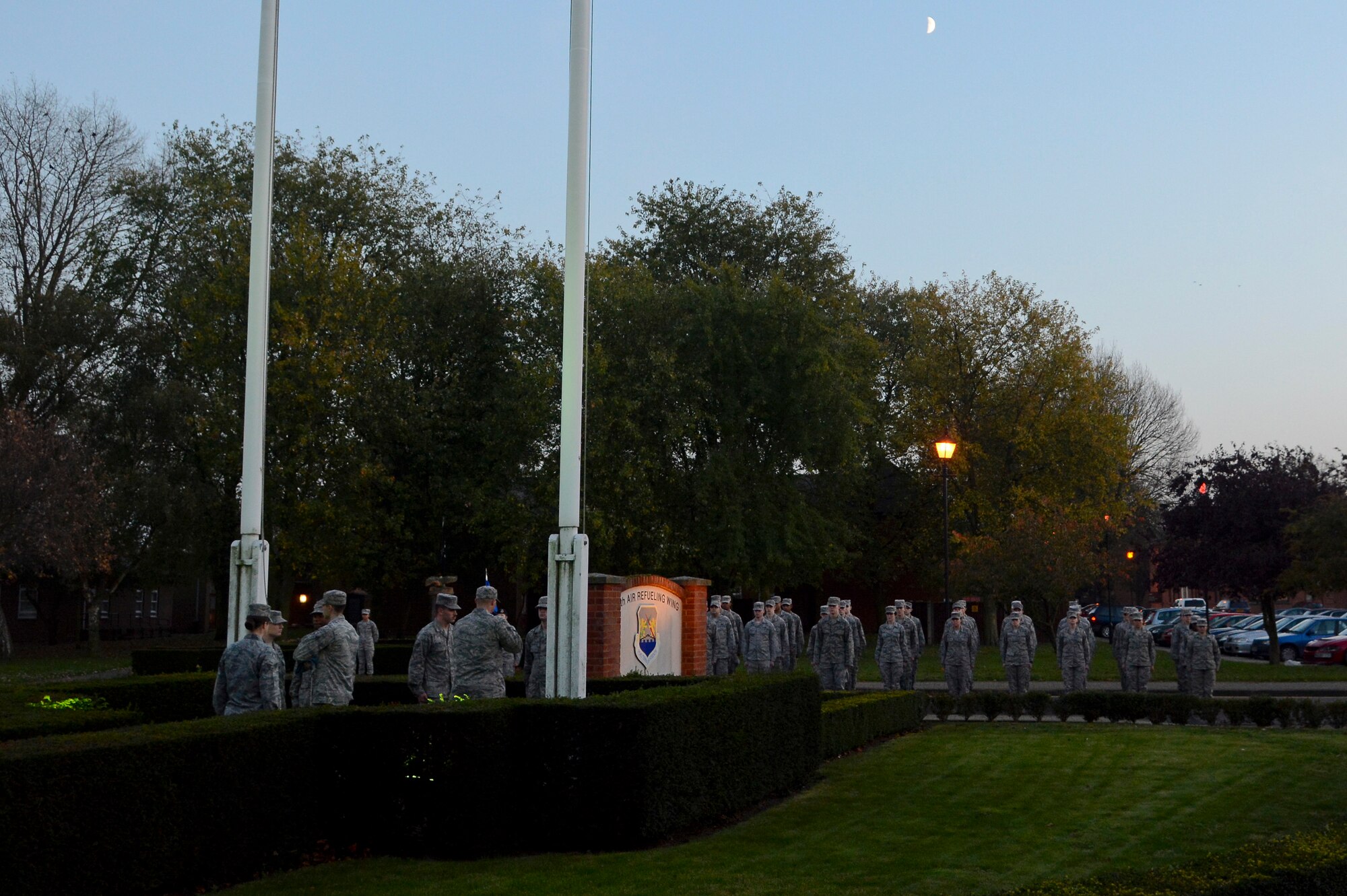 U.S. Air Force Airmen stand at attention while members of a Team Mildenhall flag detail folds the U.S. flag during a retreat ceremony Oct. 30, 2014, on RAF Mildenhall England. Airmen from the grades of E-1 through E-4 participated in the ceremony to pay their respect to the U.S. flag and Royal Air Force ensign during the ceremony. (U.S. Air Force photo by Staff Sgt. Micaiah Anthony/Released)