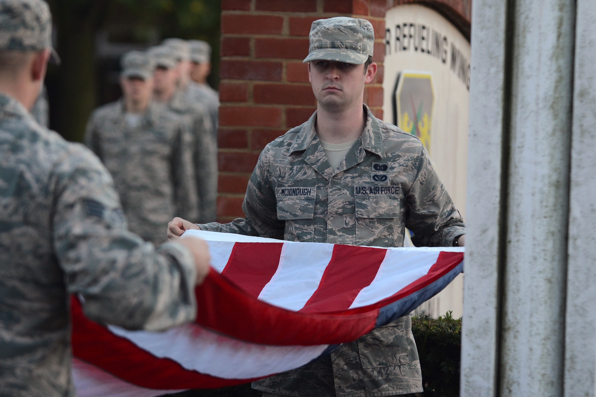 U.S. Air Force Airman 1st Class Matthew McDonough, 100th Civil Engineer Squadron emergency management journeyman from Cavot, Ark., folds the U.S. flag during a retreat ceremony Oct. 30, 2014 on RAF Mildenhall England. In the time-honored tradition of the retreat ceremony, the U.S. flag and Royal Air Force ensign are folded to signify the end of the duty day. (U.S. Air Force photo by Staff Sgt. Micaiah Anthony/Released)