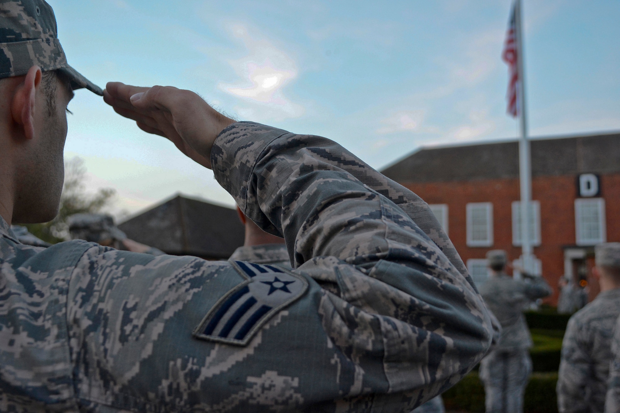 A Team Mildenhall Airman salutes the U.S. flag during a retreat ceremony Oct. 30, 2014, on RAF Mildenhall England. Airmen from the grades of E-1 through E-4 participated in the ceremony to pay their respect to the U.S. flag and Royal Air Force ensign during the ceremony. (U.S. Air Force photo by Staff Sgt. Micaiah Anthony/Released)