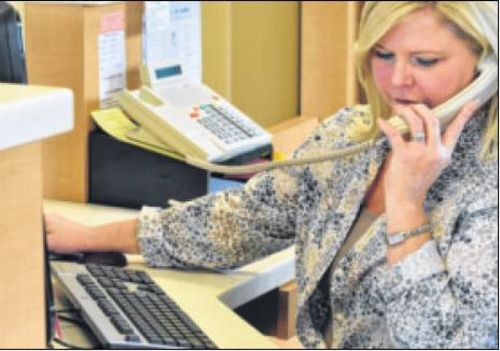 Veterinary Services Clinic receptionist Lee Booher answers calls to assist patients. The vet clinic inside Gate 15A on the base, see approximately 30 patients per day