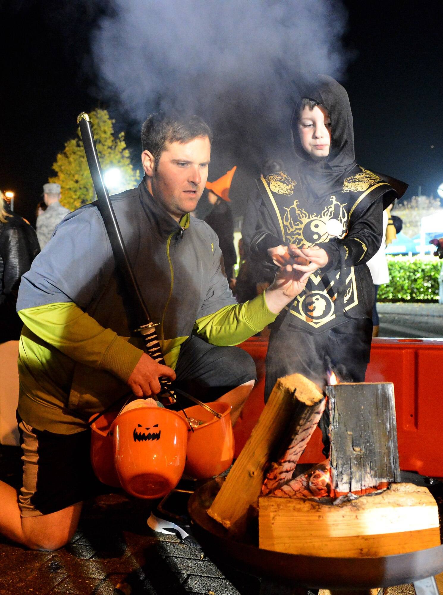 Ryan Flynn and his son Colin roast a marshmallow together at the s’mores station during Family Fright Night on Spangdahlem Air Base, Germany, Oct. 30, 2014. The 52nd Force Support Squadron put together the event so families could celebrate the holiday safely. (U.S. Air Force photo by Airman 1st Class Luke Kitterman/Released)