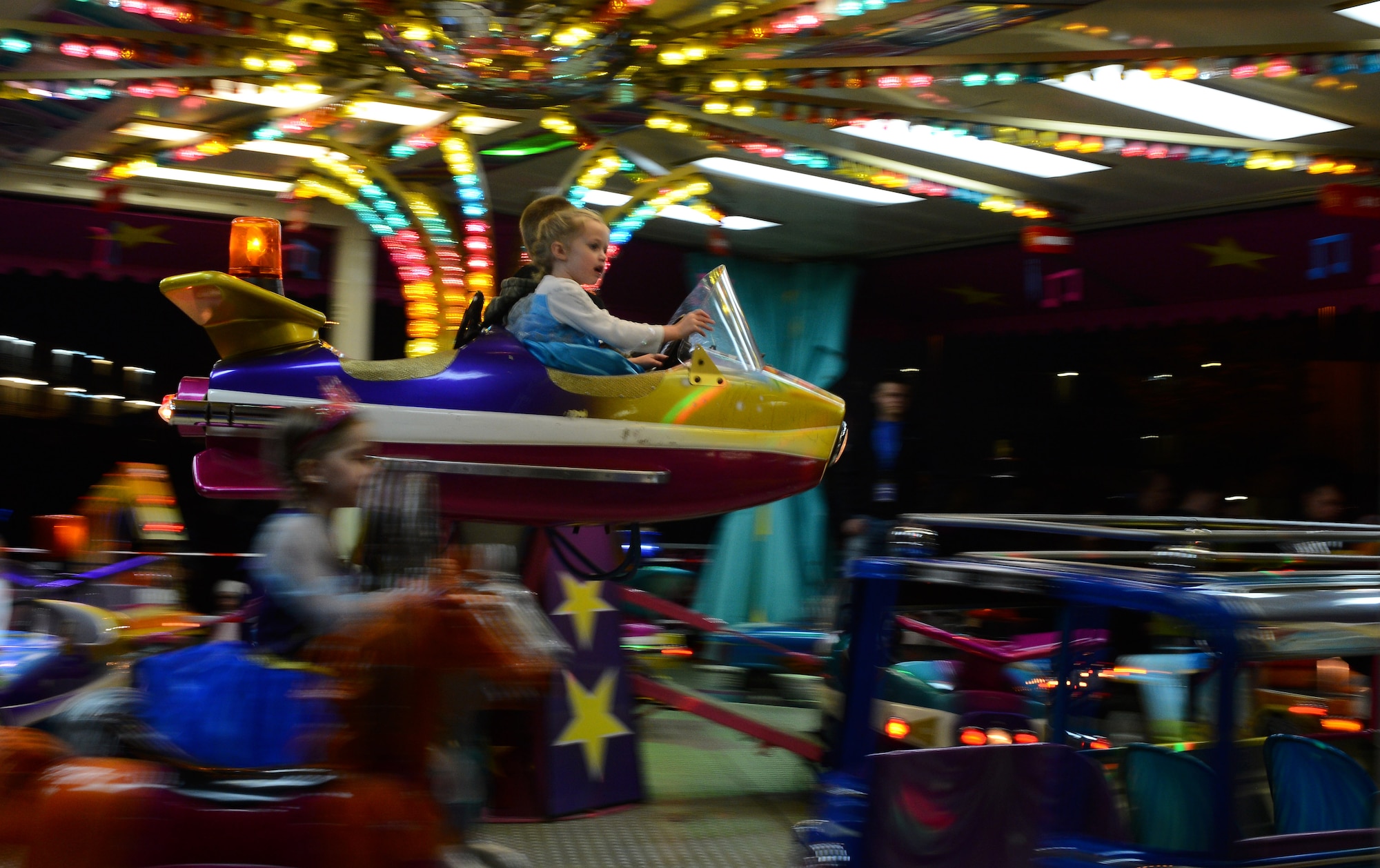 Children ride a carousel during Family Fright Night at the Club Eifel parking lot on Spangdahlem Air Base, Germany, Oct. 30, 2014. A few of the Family Fright Night events included carousel rides, a s’mores station and photo booth costume contest. (U.S. Air Force photo by Airman 1st Class Luke Kitterman/Released)