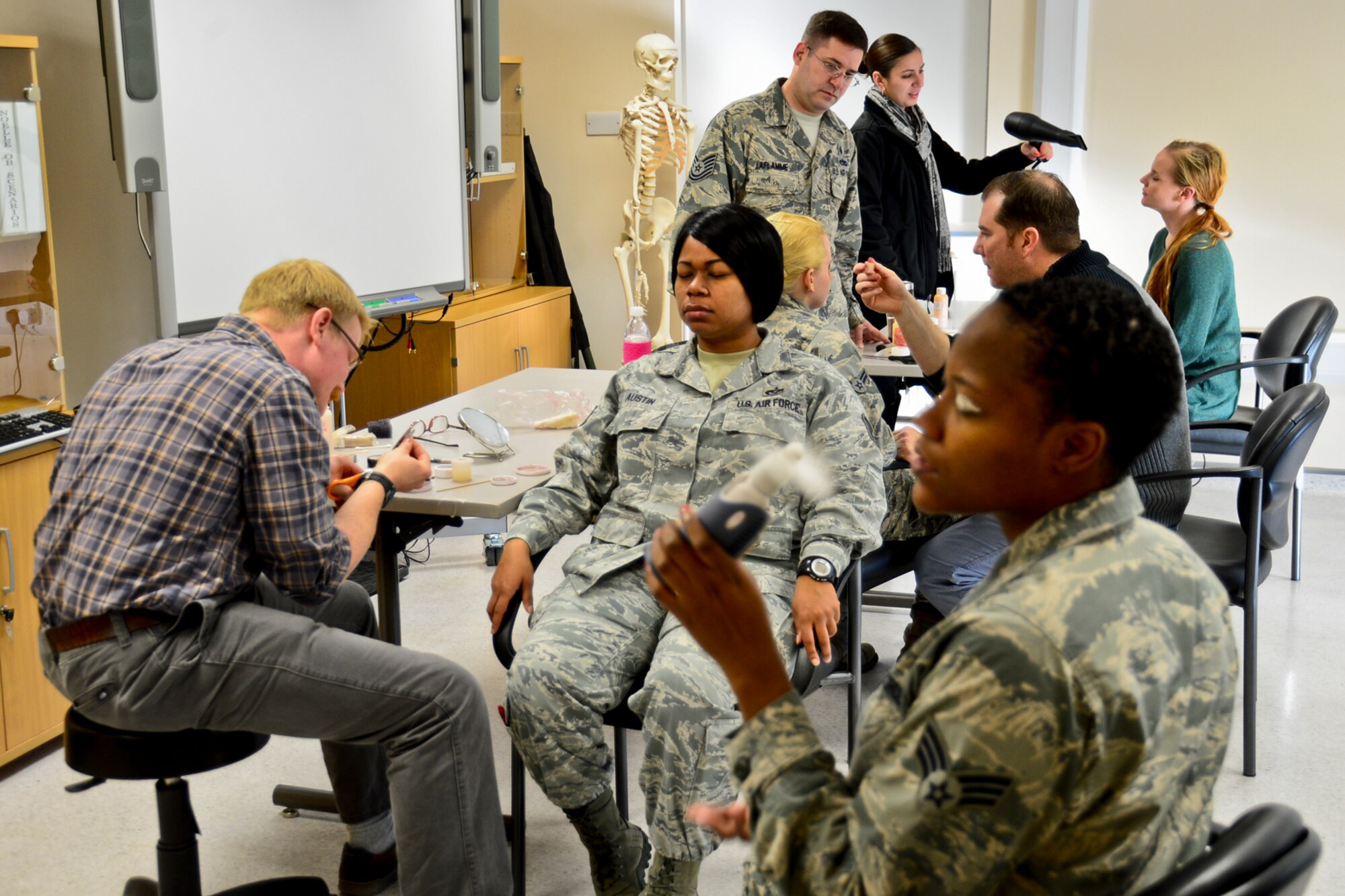 Liberty Airmen apply make-up to simulate black eyes during Domestic Violence Awareness Month at Royal Air Force Lakenheath, England, Oct. 28, 2014. The black-eye campaign was planned to reach out and educate Airmen on the issue of domestic violence and how to report it. (U.S. Air Force Photo by Airman 1st Class Erin R. Babis/Released)