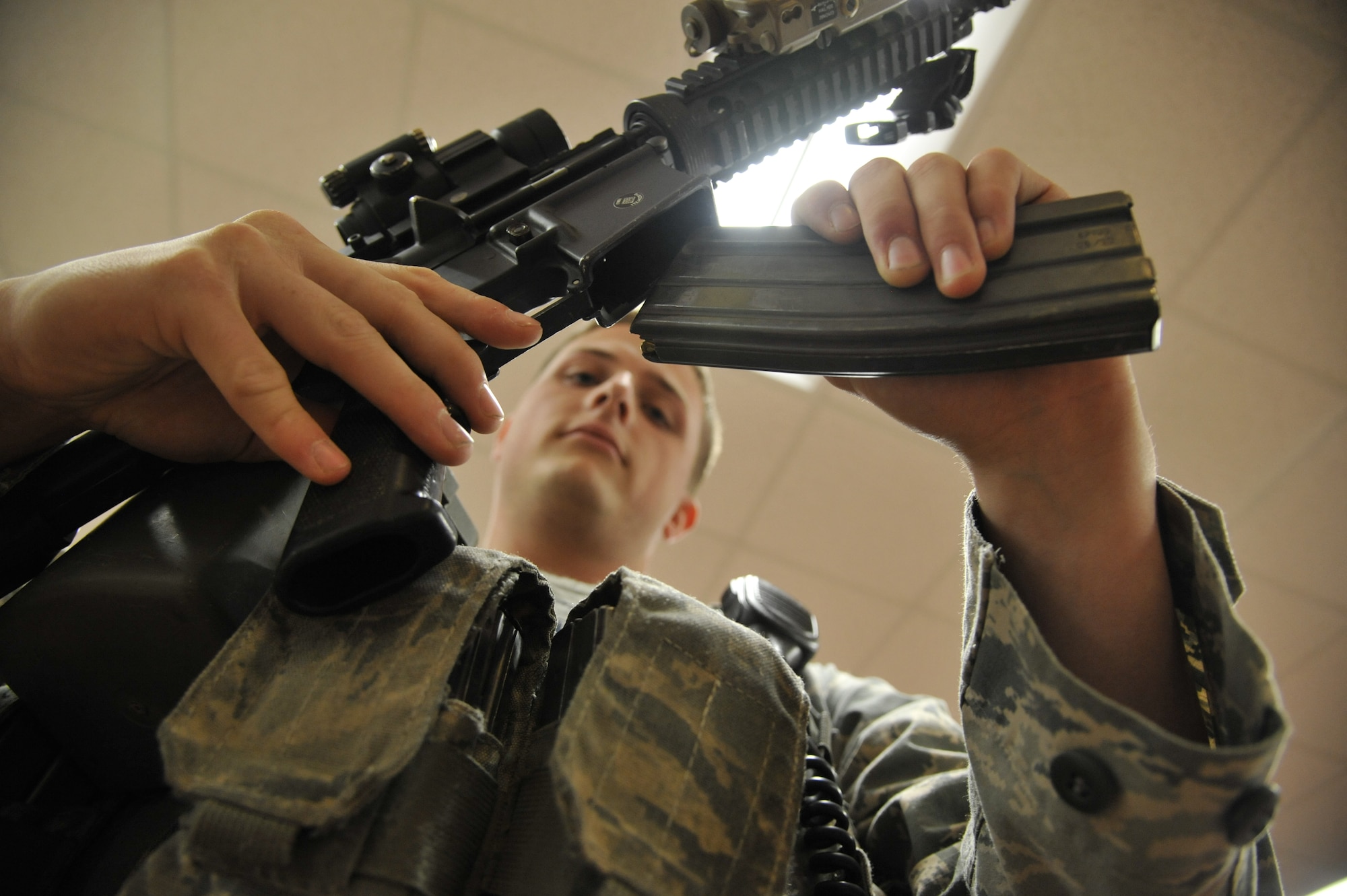 U.S. Air Force Senior Airman Matthew Hinson, 509th Security Forces Squadron patrolman, arms up for the duty day at Whiteman Air Force Base, Mo., Oct. 8, 2014. Whenever a situation occurs around the base, the desk Sgt. will alert patrolmen and dispatch to the location where situation is occurring. (U.S. Air Force photo by Airman 1st Class Keenan Berry/Released)