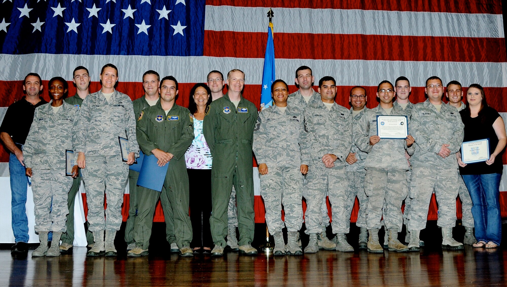 The 2014 third quarter awards winners or their representatives pause for a photo on stage at Kaye Auditorium Oct. 28. The ceremony honored the wing’s outstanding professionals for the months of July through September 2014 whose drive, determination and dedication have earned them this recognition. (U.S. Air Force Photo/Melissa Doublin)