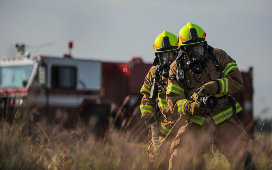 Hakan Erdal, 39th Civil Engineer Squadron firefighter, (left), and Bulut Hepsag, 39th CES crew chief, (right), respond to a simulated aircraft mishap Oct. 30, 2014, at Incirlik Air Base, Turkey. The firefighters participated in the exercise to ensure they are equipped and ready for emergencies at a moment’s notice. (U.S. Air Force photo by Airman Cory W. Bush/Released)