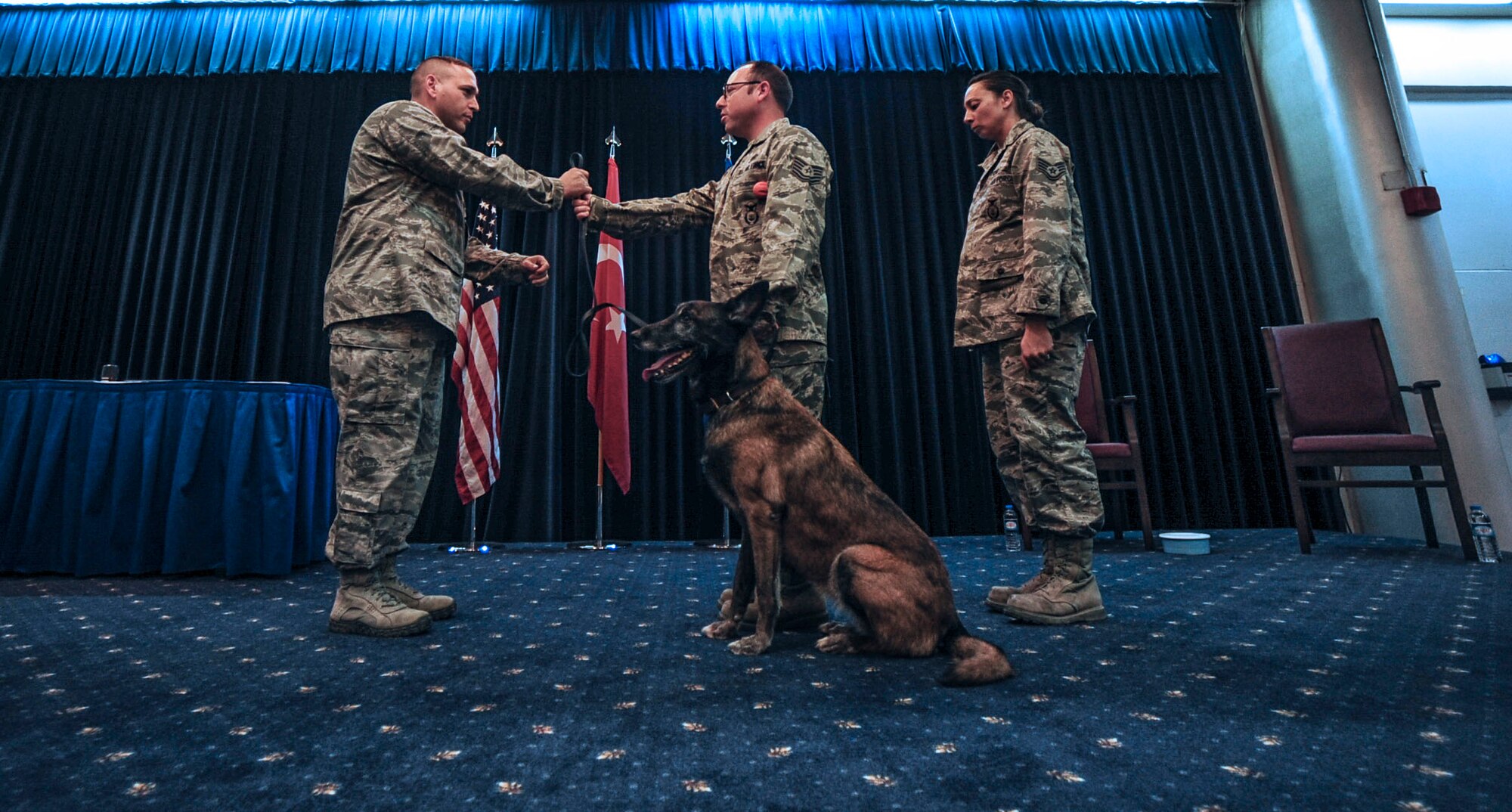 Lt. Col. Joseph Musacchia, 39th Security Forces Squadron commander, takes the leash of military working dog Kira from Tech. Sgt. Kenneth Fresquez, 39th SFS kennel master, Oct. 27, 2014, Incirlik Air Base, Turkey.  Kira has worked as an MWD in the U.S. Air Force for 10 years, eight years stationed on Incirlik AB as a narcotic K-9. (U.S. Air Force photo by Senior Airman Nicole Sikorski/Released)