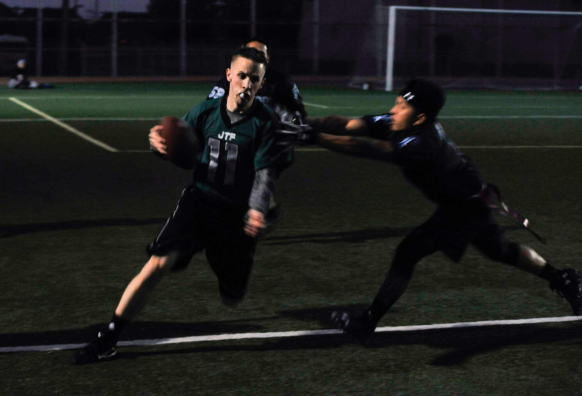Daniel Bodine, 7th Air Force, gets tagged by a defender during an intramural flag football game against the 51st Force Support Squadron team Oct. 29, 2014, on Osan Air Base, Republic of Korea. Bodine gained 12-yards during the run. (U.S. Air Force photo by Senior Airman David Owsianka)