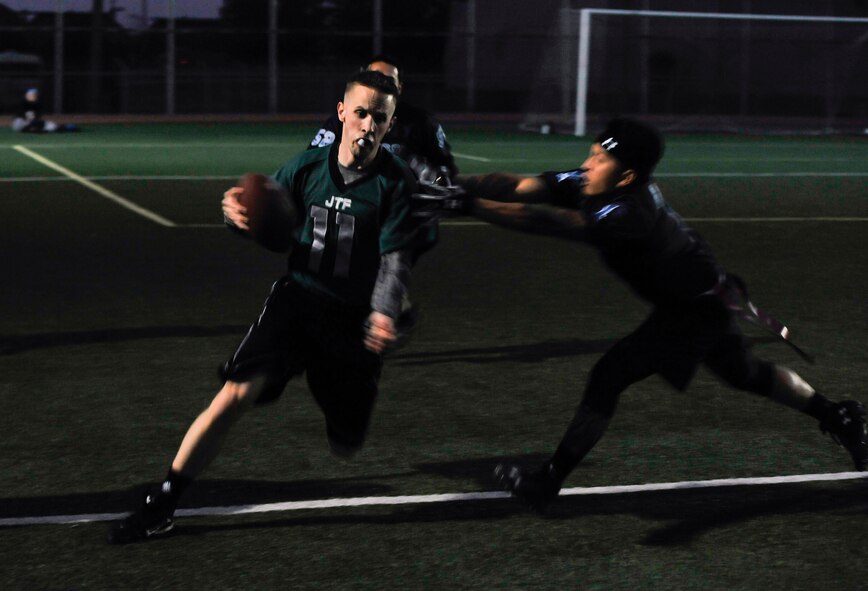 Daniel Bodine, 7th Air Force, gets tagged by a defender during an intramural flag football game against the 51st Force Support Squadron team Oct. 29, 2014, on Osan Air Base, Republic of Korea. Bodine gained 12-yards during the run. (U.S. Air Force photo by Senior Airman David Owsianka)