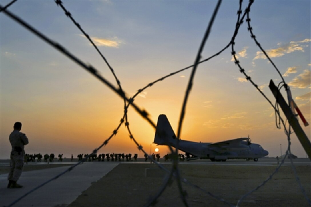 U.S. Marine Corps Brig. Gen. Daniel D. Yoo, commanding general of Regional Command Southwest, watches as U.S. Marines and coalition forces board a KC-130 Hercules aircraft to depart the Bastion-Leatherneck Complex in Helmand province, Afghanistan, Oct. 27, 2014.