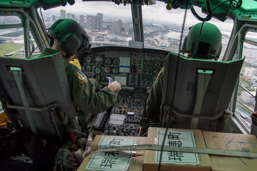(Left to right) Capt. Stephen Jones, 459th Airlift Squadron UH-1N pilot, and Maj. Destry Hill, 5th Air Force UH-1N pilot, fly over Tokyo, Aug. 30, 2014 during the Tokyo Metropolitan Government and Suginami City Joint Comprehensive Disaster Management Drill. Yokota personnel practiced delivering simulated relief supplies to Ariake no Oka core wide-area disaster prevention base in downtown Tokyo. (U.S. Air Force photo by Staff Sgt. Dustin Payne/Released)