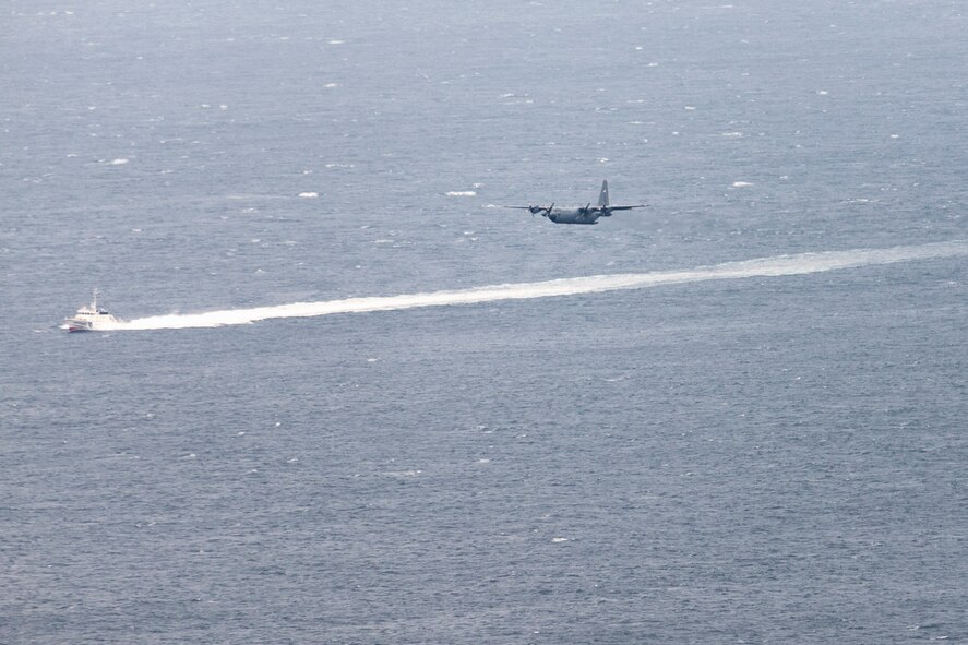 A vessel from Japan Coast Guard leads a C-130 Hercules from the 36th Airlift Squadron towards an airdrop zone at Sagami bay, Shizuoka prefecture, Japan, Aug. 31, 2014, during the annual Shizuoka Comprehensive Disaster Drill. (U.S. Air Force photo by Osakabe Yasuo/Released) 