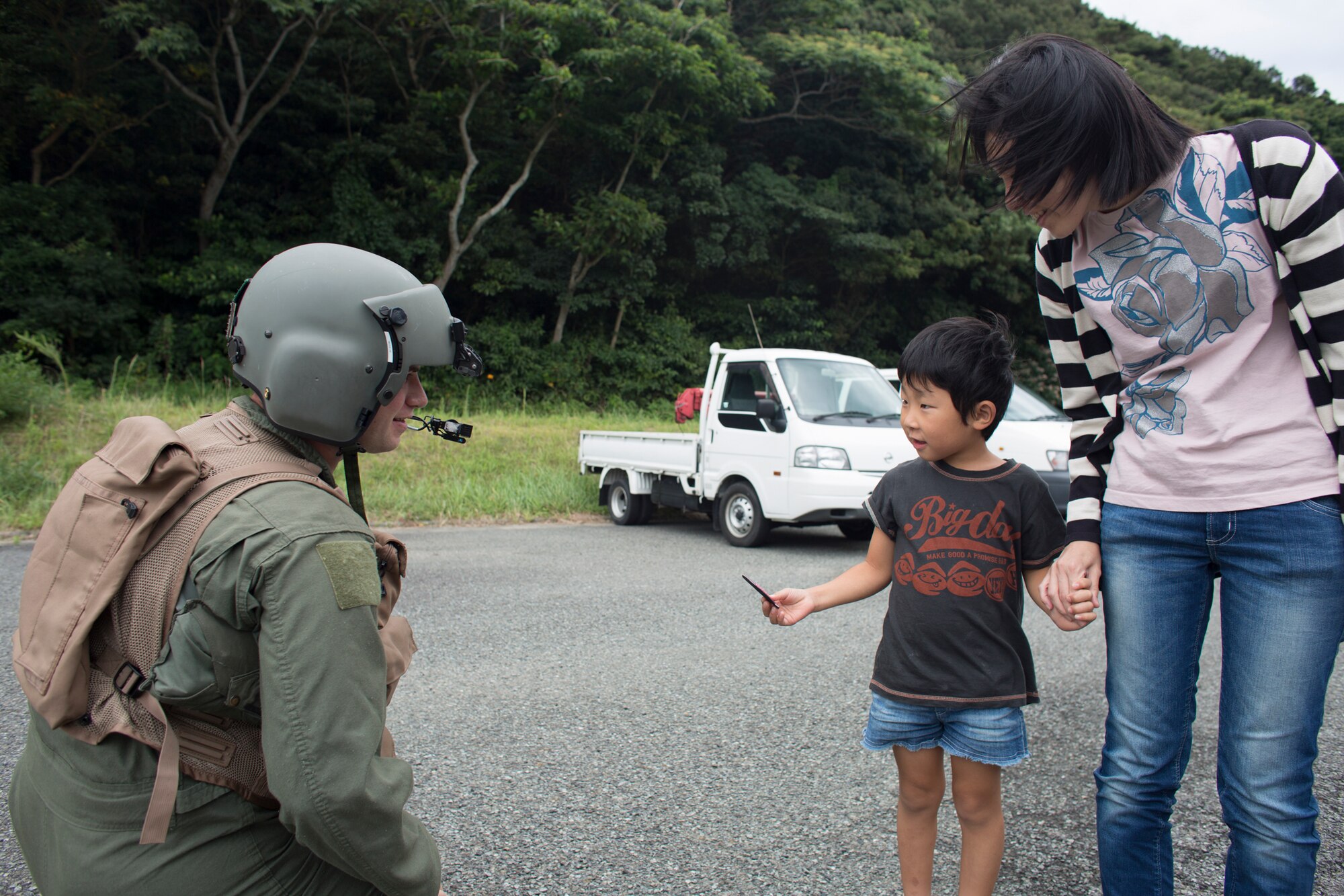 Staff Sgt. Christopher Rector, 459th Airlift Squadron flight engineer, presents his squadron patch to a local boy at Shimoda Helipad, Shizuoka prefecture, Japan, Aug. 31, 2014, during the Shizuoka Comprehensive Disaster Drill. UH-1N Iroquois crewmembers cleared a water Drop Zone for a C-130 Hercules airdrop. (U.S. Air Force photo by Osakabe Yasuo/Released) 