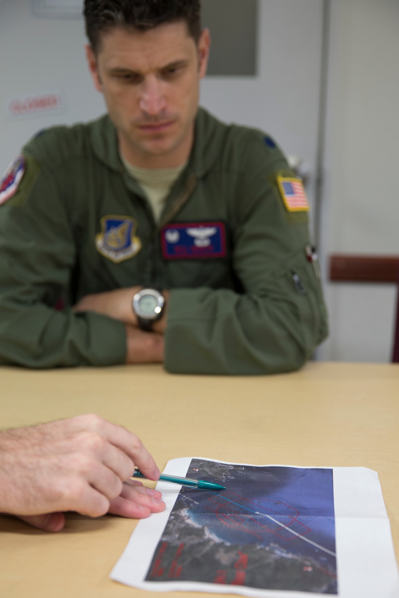 Lt. Col. William Martin, 459th Airlift Squadron commander, checks planned routes on a map during a pre-flight briefing at Yokota Air Base, Japan, Aug. 31, 2014, during the Shizuoka Comprehensive Disaster Drill. UH-1N crew members used dye in the water to mark the Drop Zone for a C-130 Hercules airdrop. (U.S. Air Force photo by Osakabe Yasuo/Released)