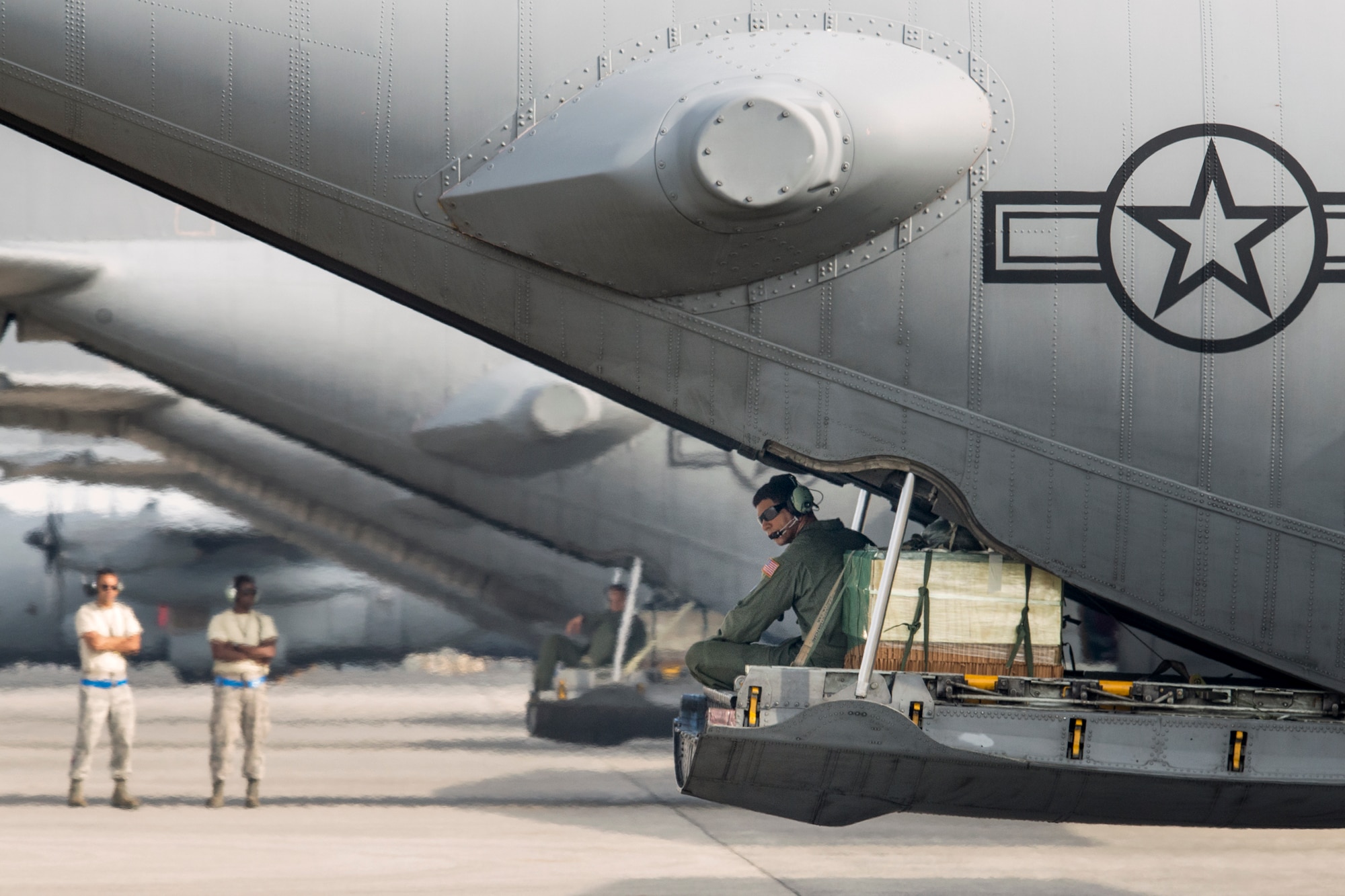 Staff Sgt. Napoleon Ortiz, a 36th Airlift Squadron loadmaster, communicates with his crewmembers at Yokota Air Base, Japan, Aug. 31, 2014, during the Shizuoka Comprehensive Disaster Drill. A C-130 Hercules from the 36th AS airlifted Japan Ground Self Defense Force members to Shizuoka airport and performed an airdrop of simulated humanitarian supplies to a coastal drop zone near Shimoda in the Shizuoka prefecture. (U.S. Air Force photo by Osakabe Yasuo/Released)