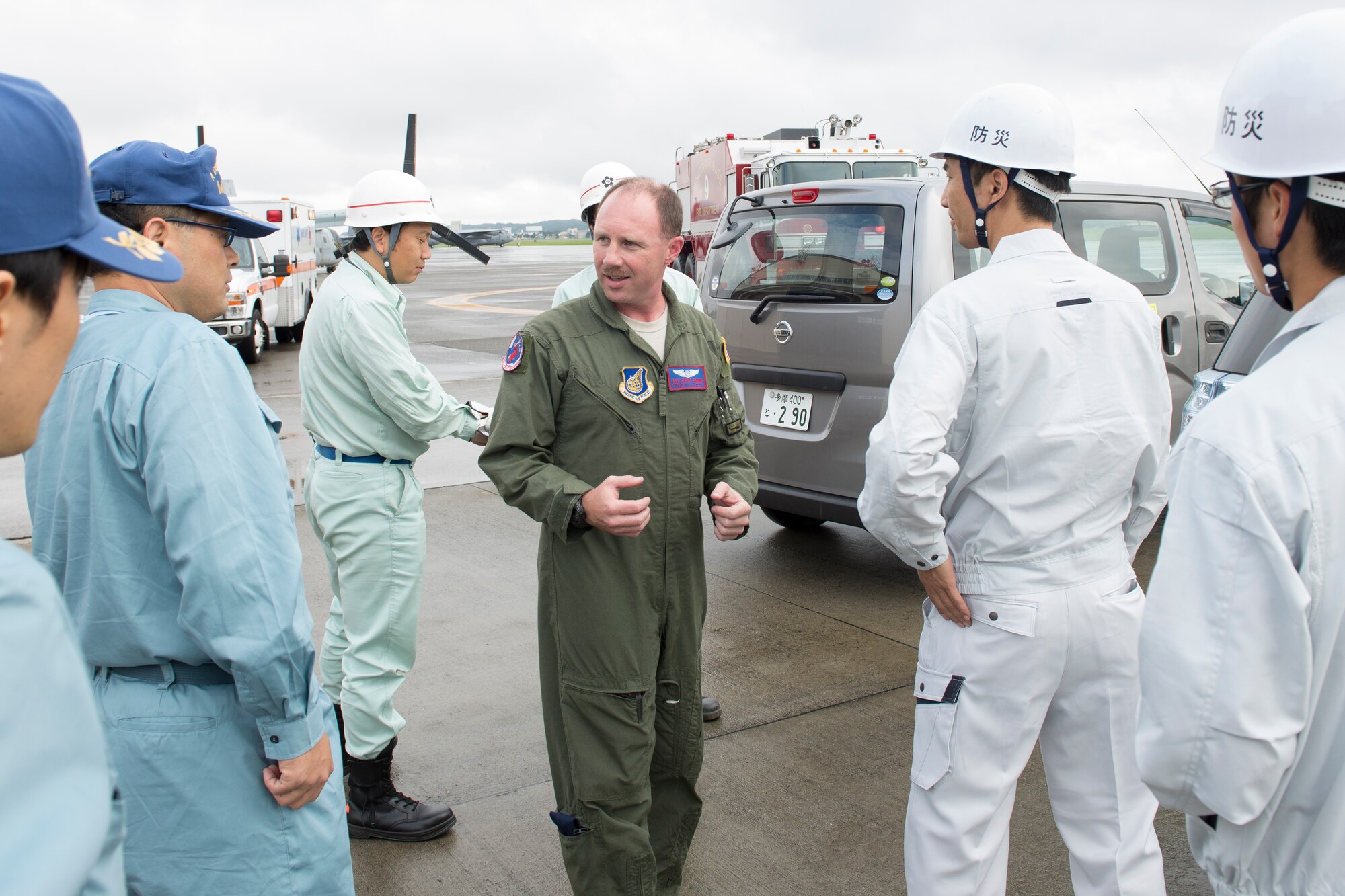 Tech. Sgt. David Jacobs, 459th Airlift Squadron UH-1N flight engineer, conducts a briefing with staff members from Tachikawa city, Fussa city and Mizuho town before loading simulated relief supplies into an UH-1N Huey at Yokota Air Base, Japan, Aug. 30, 2014.  Yokota Airmen were participating in the annual Tokyo Metropolitan Government Comprehensive Disaster Management Drill. (U.S. Air Force photo by Osakabe Yasuo/Released)