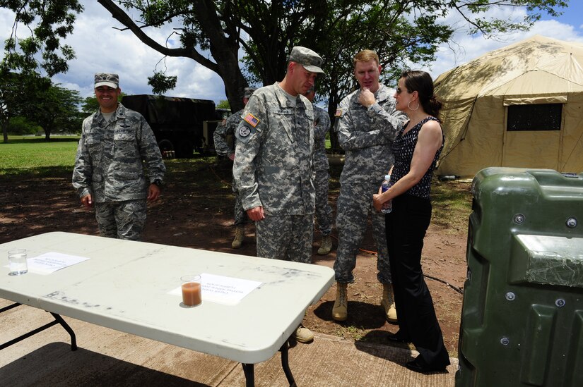 U.S. Army Sgt Kirk Marra, Army Forces Battalion, shows the before and after glasses of water and explains the water purification process of the Pre-Positioned Expeditionary Assistance Kit (PEAK) system to Dr. Rebecca Chavez, the Deputy Assistant Secretary of Defense for Western Hemisphere Affairs, Aug. 28 during a command tour of Joint Task Force-Bravo at Soto Cano Air Base, Honduras.  (Photo by Martin Chahin)