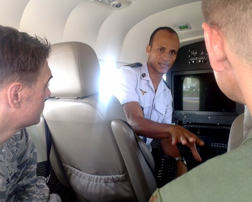 Mauritanian Air Force Captain, Eyoub Teyss, intelligence, surveillance and reconnaissance operations officer, briefs U.S. Air Force Maj. Michael Simons, African Partnership Flight Mauritania lead planner, left, and U.S. Air Force Maj. Steven Payne, ISR instructor, about the ISR capabilities on the Cessna 208 Grand Caravan during a tour of the aircraft at Atar Airbase, Atar, Mauritania, Sept. 1, 2014.  The Cessna 208 is the premier aircraft used by the Mauritanian Air Force to ensure safety and security in the region. (U.S. Air Force photo/Master Sgt. Brian Boisvert/Released)