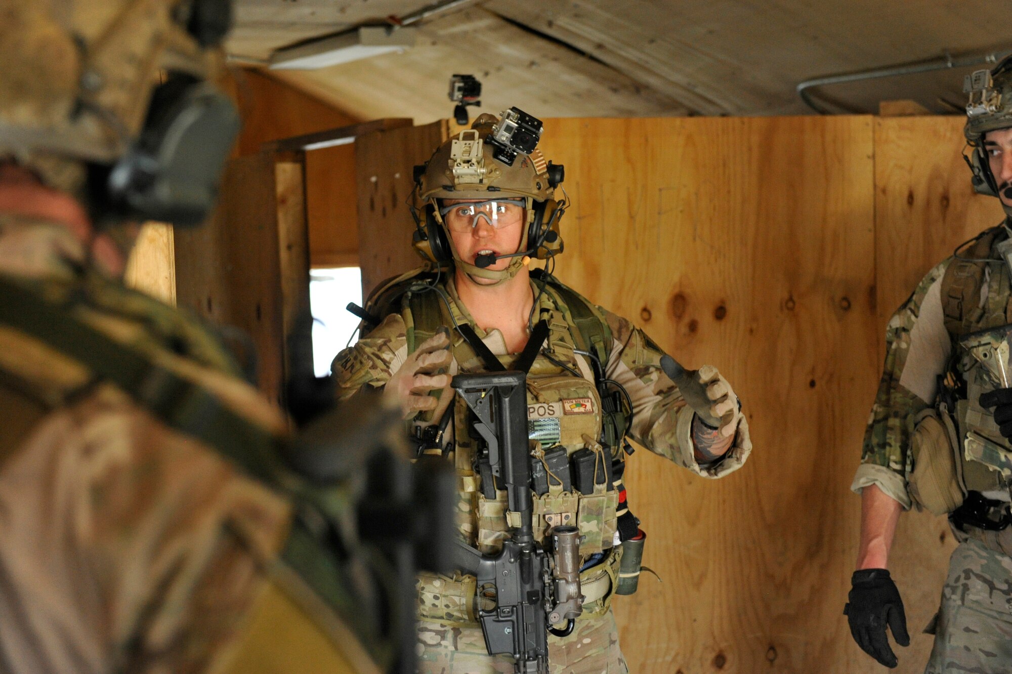 U.S. Air Force Staff Sgt. Jason Lee, 83rd Expeditionary Rescue Squadron pararescue element leader, talks with his teammates about their clearing procedures during a mission rehearsal in an excess structure here Aug. 26, 2014. The event allowed PJs to hone their breaching, clearing, patient care and egress skills. Air Force rescue forces conduct combat search and rescue and personnel recovery operations. Lee, from Richmond, Ky., is an Air National Guardsmen deployed from the 123rd Special Tactics Squadron, Louisville, Ky. The 83rd ERQS partnered with Joint Task Force Trailblazer, U.S. Army 2nd Engineer Brigade, to use the structure prior to its scheduled deconstruction. Task Force Trailblazer is currently demolishing 50-70 wooden structures here each week as part of Operation Enduring Freedom retrograde operations. (U.S. Air Force photo by Maj. Brandon Lingle/Released)