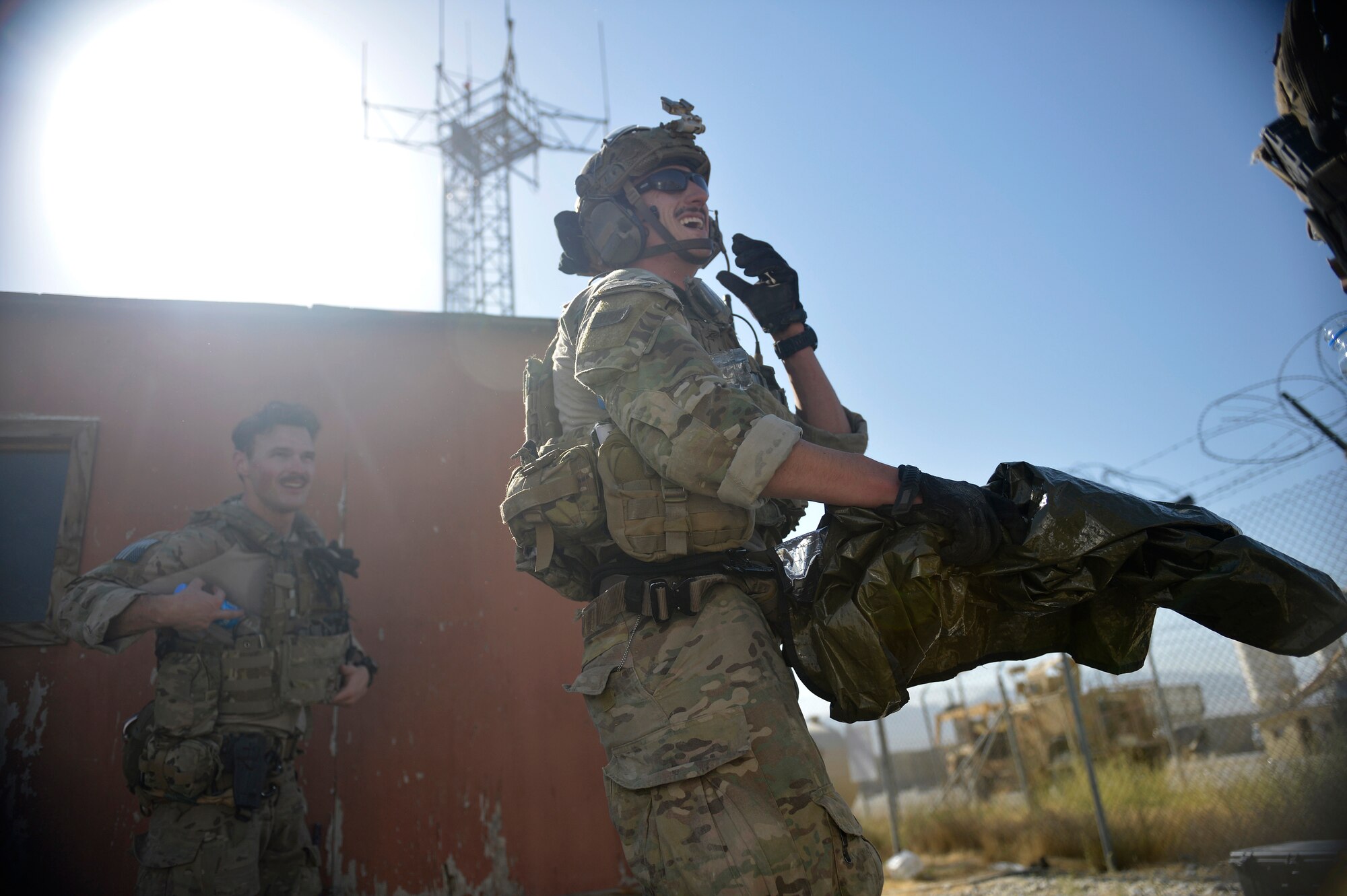 Airmen assigned to the 83rd Expeditionary Rescue Squadron laugh after a mission rehearsal at Bagram Airfield, Afghanistan Aug. 26, 2014.  During the rehearsal, they breached and cleared a building to rescue a simulated casualty. (U.S. Air Force photo by Staff Sgt. Evelyn Chavez/Released)