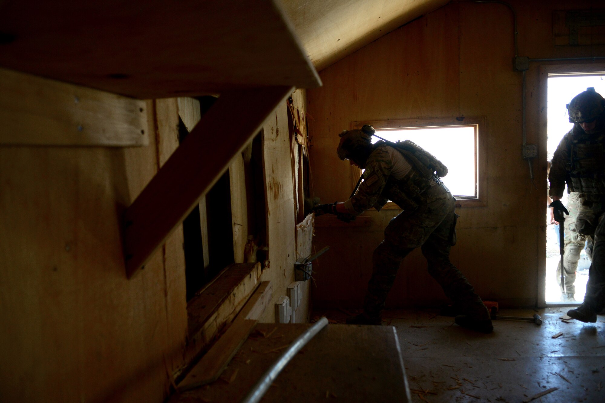 U.S. Air Force Master Sgt. Ryan Darnell, 83rd Expeditionary Rescue Squadron pararescue team leader, breaks through a wall during a mission rehearsal in an excess structure at Bagram Airfield, Afghanistan Aug. 26, 2014.  During the mission rehearsal, they breached and cleared a building to rescue a simulated casualty. Darnell is deployed from the 123rd Special Tactics Squadron in Louisville, Ky. and a native Romulus, Mich. (U.S. Air Force photo by Staff Sgt. Evelyn Chavez/Released)