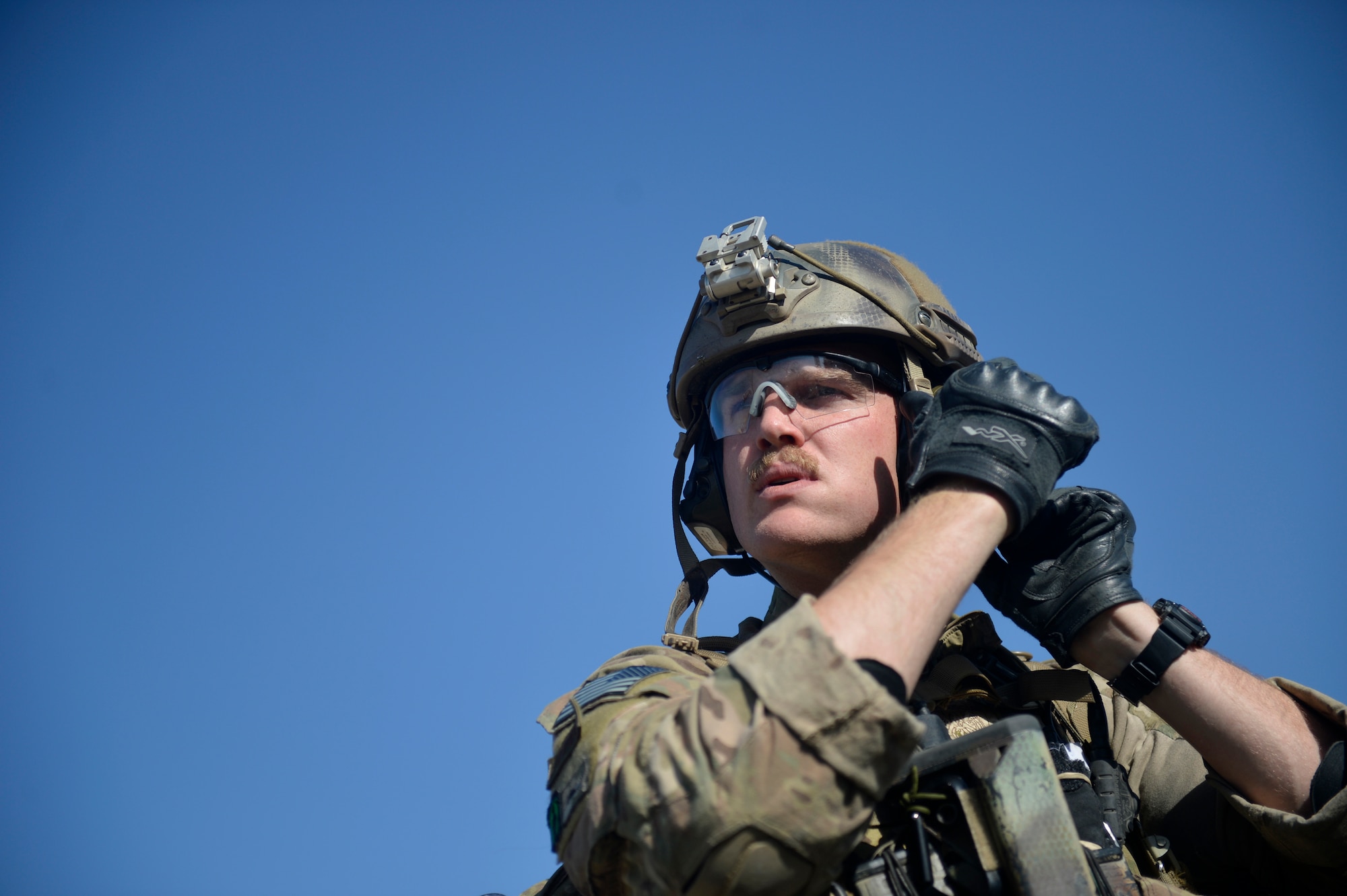 U.S. Air Force Senior Airman Jake Racicot 83rd Expeditionary Rescue Squadron pararescue team member, adjusts his helmet before a mission rehearsal at Bagram Airfield, Afghanistan Aug. 26, 2014.  The unit honed their skills during a mission rehearsal by practicing breaching, clearing, rescuing a simulated casualty and egressing. Racicot is deployed from Davis-Monthan Air Force Base, Ariz. and a native of Reno, Nev. (U.S. Air Force photo by Staff Sgt. Evelyn Chavez/Released)
