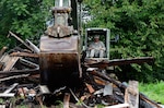 A Soldier from Virginia Army National Guard’s 180th Engineer Company uses an excavator to demolish an abandoned structure in Petersburg, Virginia as part of Operation Renew. Operation Renew provides Virginia National Guard engineer assets to assist local authorities in reclaiming control of known drug trafficking areas by destroying abandoned structures known to have ties to the local drug trade. The program operates under the supervision of the Virginia Guard Counterdrug Task Force and in conjunction with local law enforcement.