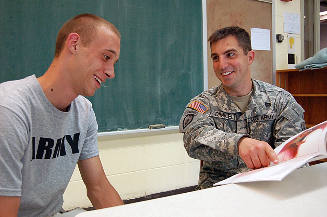 U.S. Army Staff Sgt. Nicholas Dimiceli, Milwaukee Recruiting Battalion, reunites with Jacob Beringer, a school buddy from a decade ago at St. Agnes School in Butler, Wisconsin. Dimiceli was an eighth grader who read books and did various activities with Beringer who was then a first grader. They sit in a classroom where they both went through eighth grade. Beringer is now joining the Army following his reunion with Dimiceli. (U.S. Army photo by Jorge Gomez/Released)