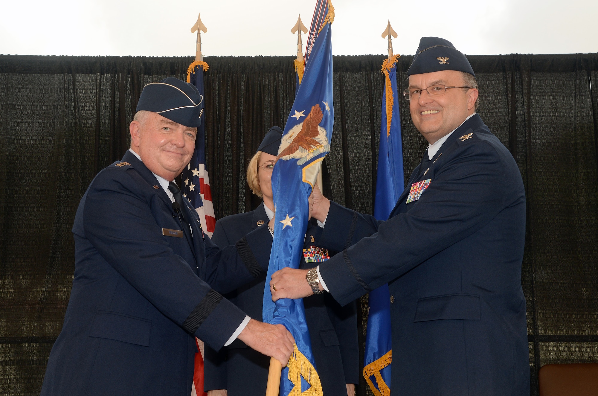 Col. Lee E. Payne accepts the guidon from Lt. Gen. Thomas W. Travis, Surgeon General of the Air Force, and assumes command of the Air Force Medical Operations Agency during a change of command ceremony at Joint Base San Antonio-Lackland Kelly Field Annex Aug. 29, 2014.  AFMOA oversees the execution of the Air Force Surgeon General policies supporting Air Force expeditionary capabilities, healthcare operations and national security strategy. Col. Payne will be responsible for leading consultative support of over 43,000 personnel, 75 Medical Treatment Facilities with a $6.1 billion budget. (U.S. Air Force Photo by Johnny Saldivar)
