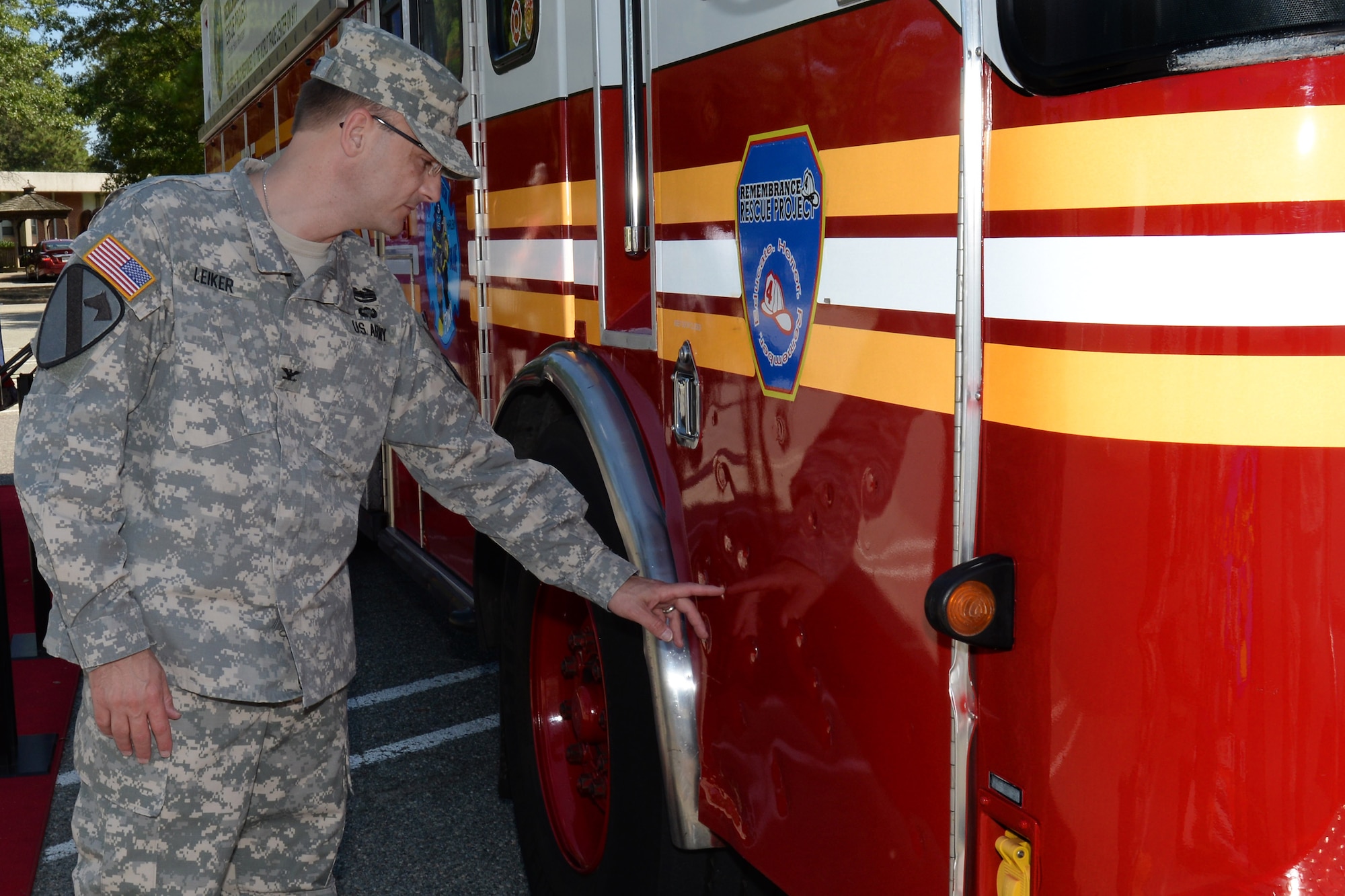 U.S. Army Col. Cameron Leiker, former U.S. Army Training and Doctrine Command Headquarters chief knowledge officer, feels damages on the Remembrance Rescue Project Rescue 4 fire truck at Fort Eustis, Va., Aug. 26, 2014. Firefighters created the project to restore Rescues 4 and 5 from the Fire Department of New York and travel along the coasts to honor and remember those lost on 9/11. (U.S. Air Force photo by Staff Sgt. Teresa J. Cleveland/Released)