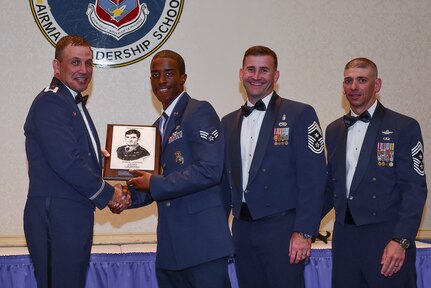 Col. John Lamontagne, 437th Airlift Wing commander (left), Chief Master Sgt. Mark Bronson, 628th Air Base Wing command chief (second from right), and Chief Master Sgt. Shawn Hughes, 437th AW command chief, present the John L. Levitow Award to Senior Airman Christopher Moore, 628th Security Forces Squadron patrolman, during the Airman Leadership School Class graduation August 28, 2014, at Joint Base Charleston, S.C. The Levitow award is given for a student's exemplary demonstration of excellence, both as a leader and a scholar. (U.S. Air Force photo/ Senior Airman Dennis Sloan)